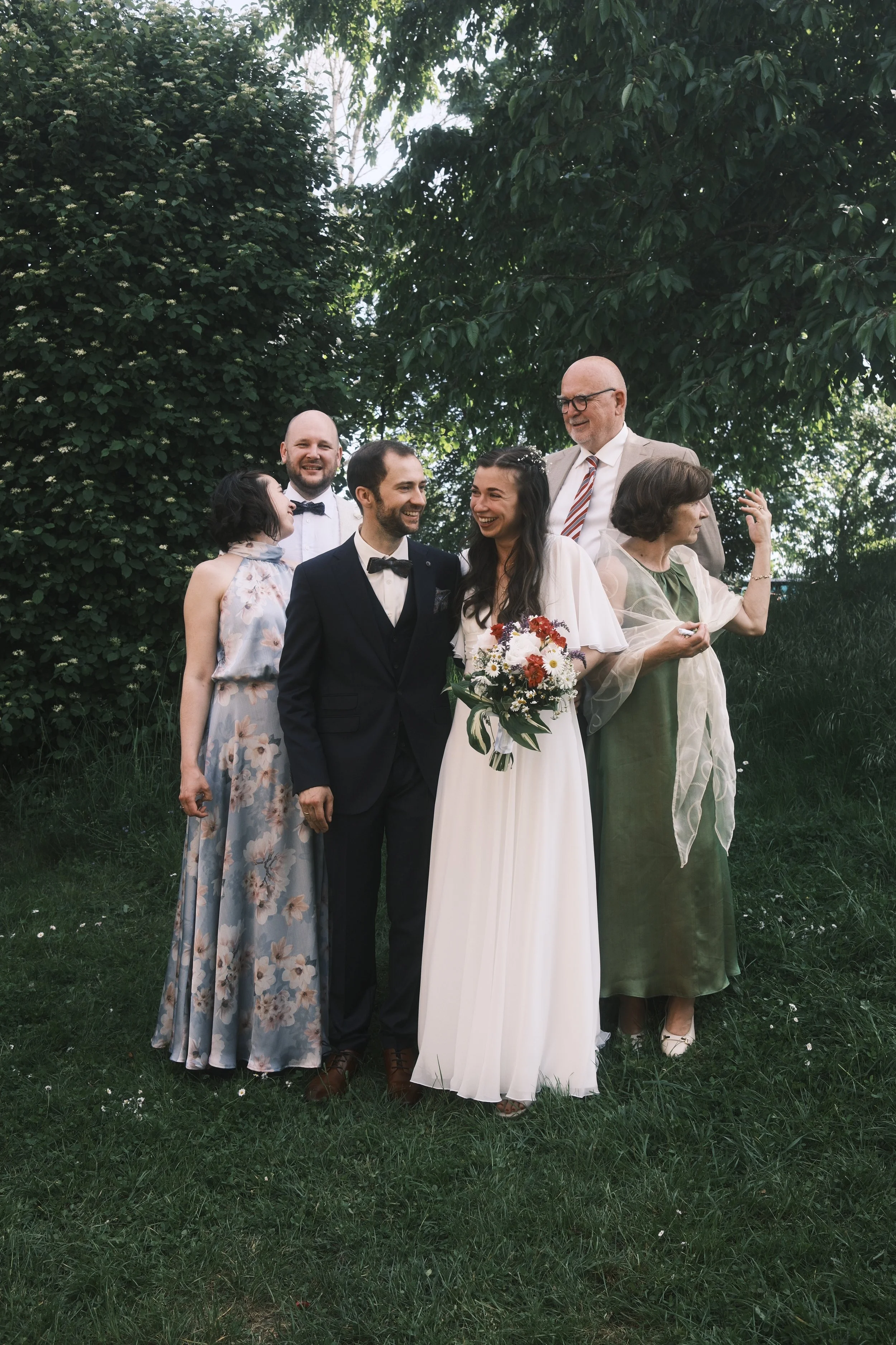 Hochzeitsfotograf Leipzig – lachende Hochzeitsgesellschaft im Garten