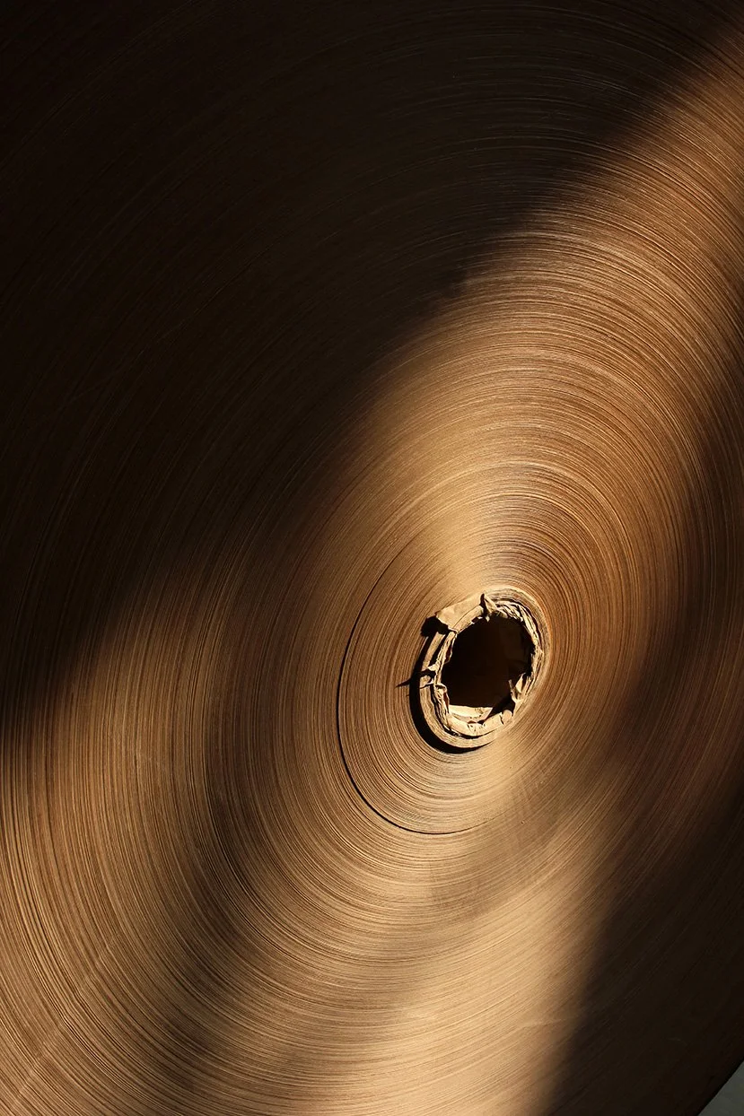 Close-up of a copper-colored roll of metal with a hole in the center.