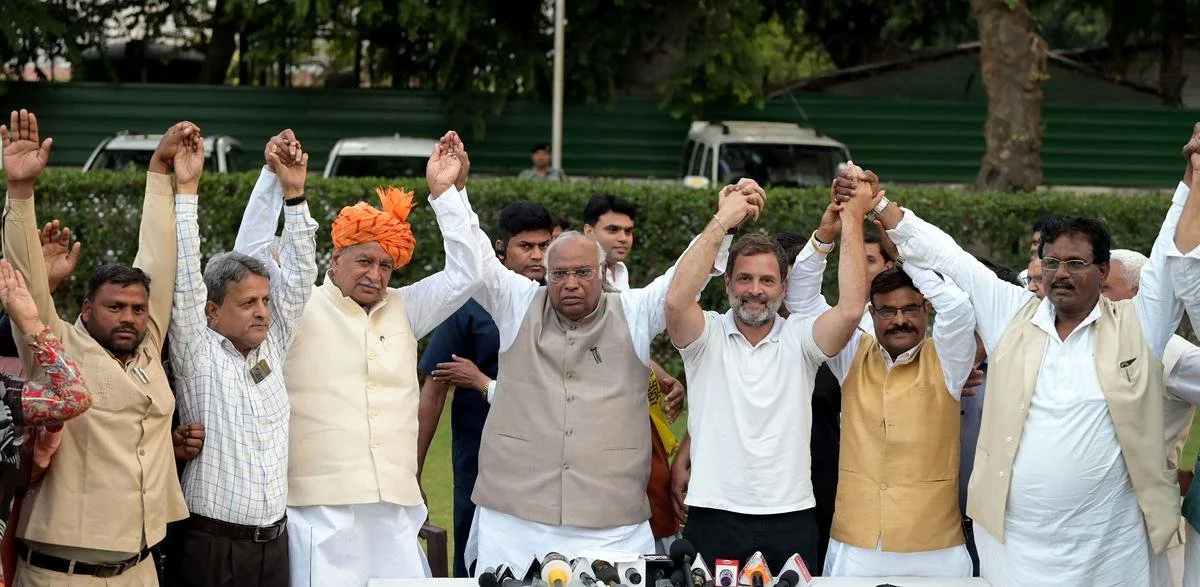 Group of Indian men holding hands in celebration or solidarity outdoors.