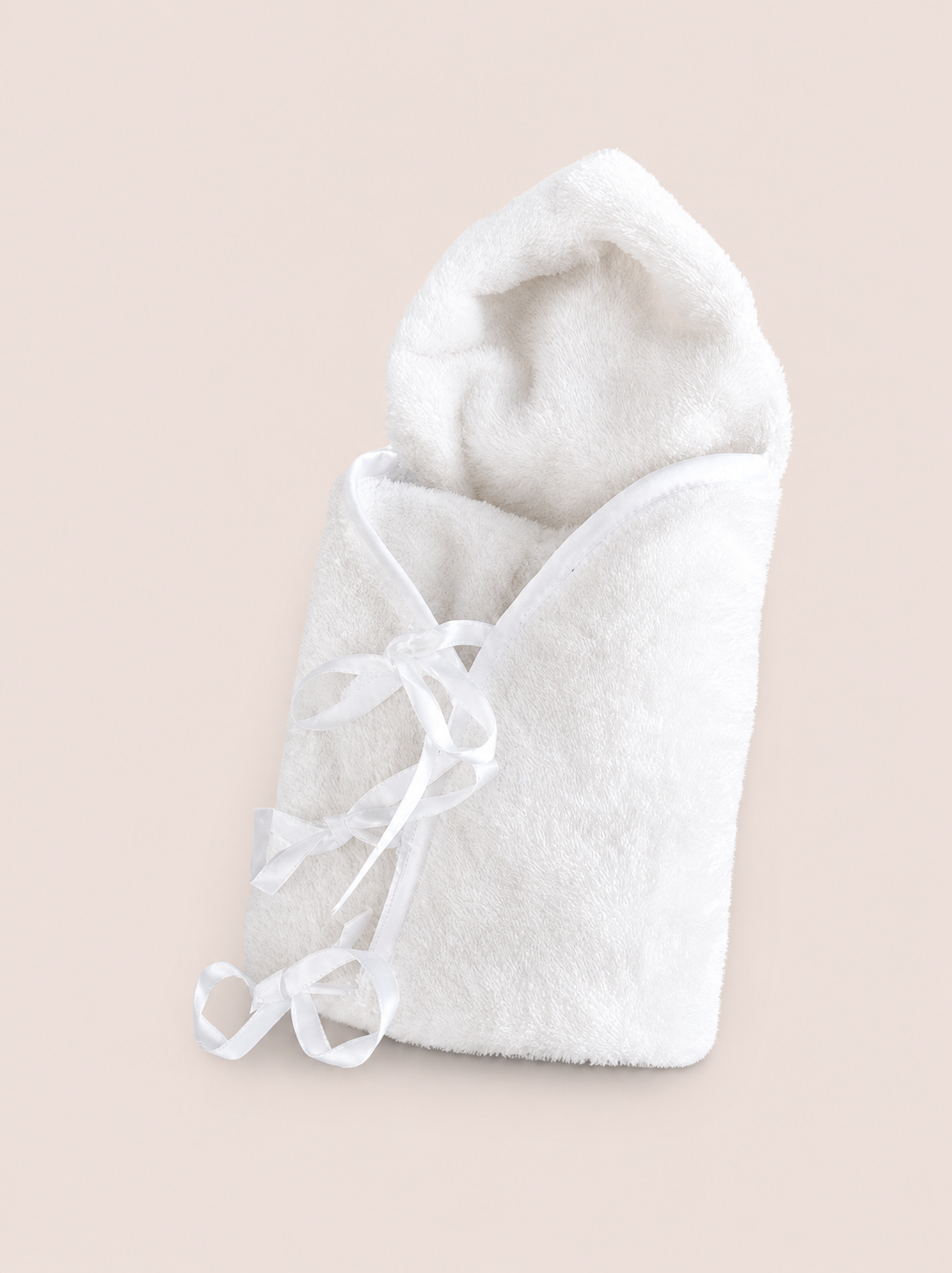 Un linge de bain blanc en forme de bébé enveloppé dans une serviette à capuche, avec des rubans en satin blanc.