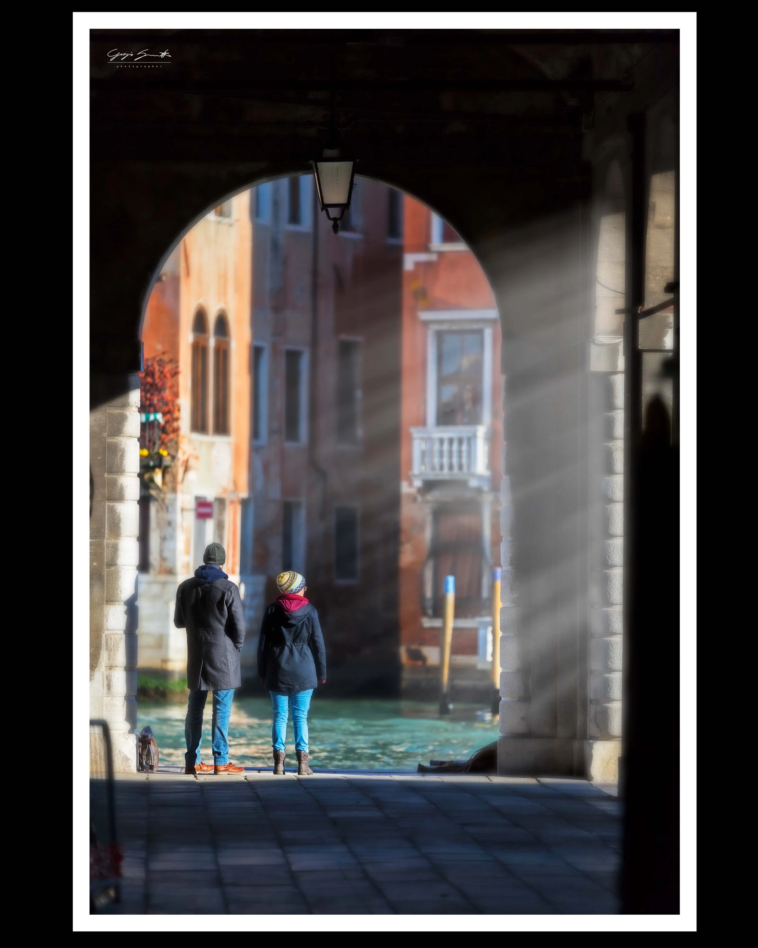 Venice canal street — two figures walking through historic brick archway in winter — fine art street photography print by Hermes Gray, limited edition