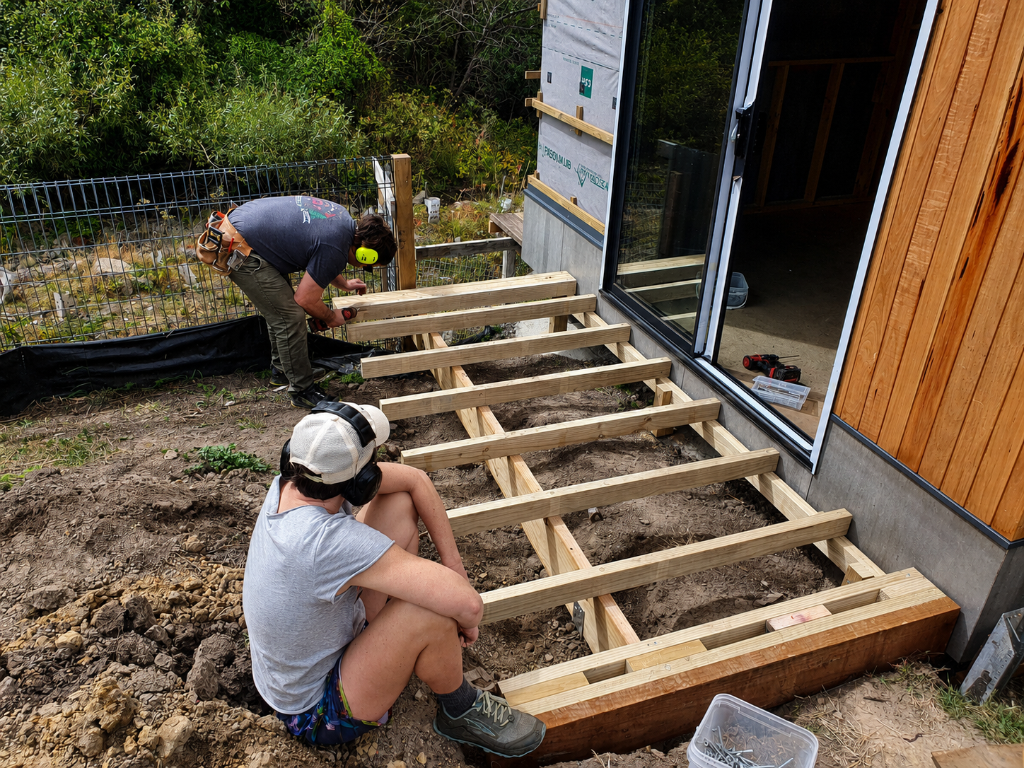 Mentorees finishing the framing of a small deck under the guidance of Ground Up's mentorship program