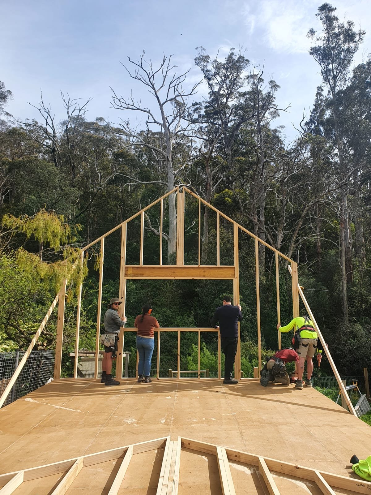 Students learning timber framing at a Ground Up woodworking workshop in Hobart, Tasmania, building a timber wall frame with hands-on carpentry instruction.