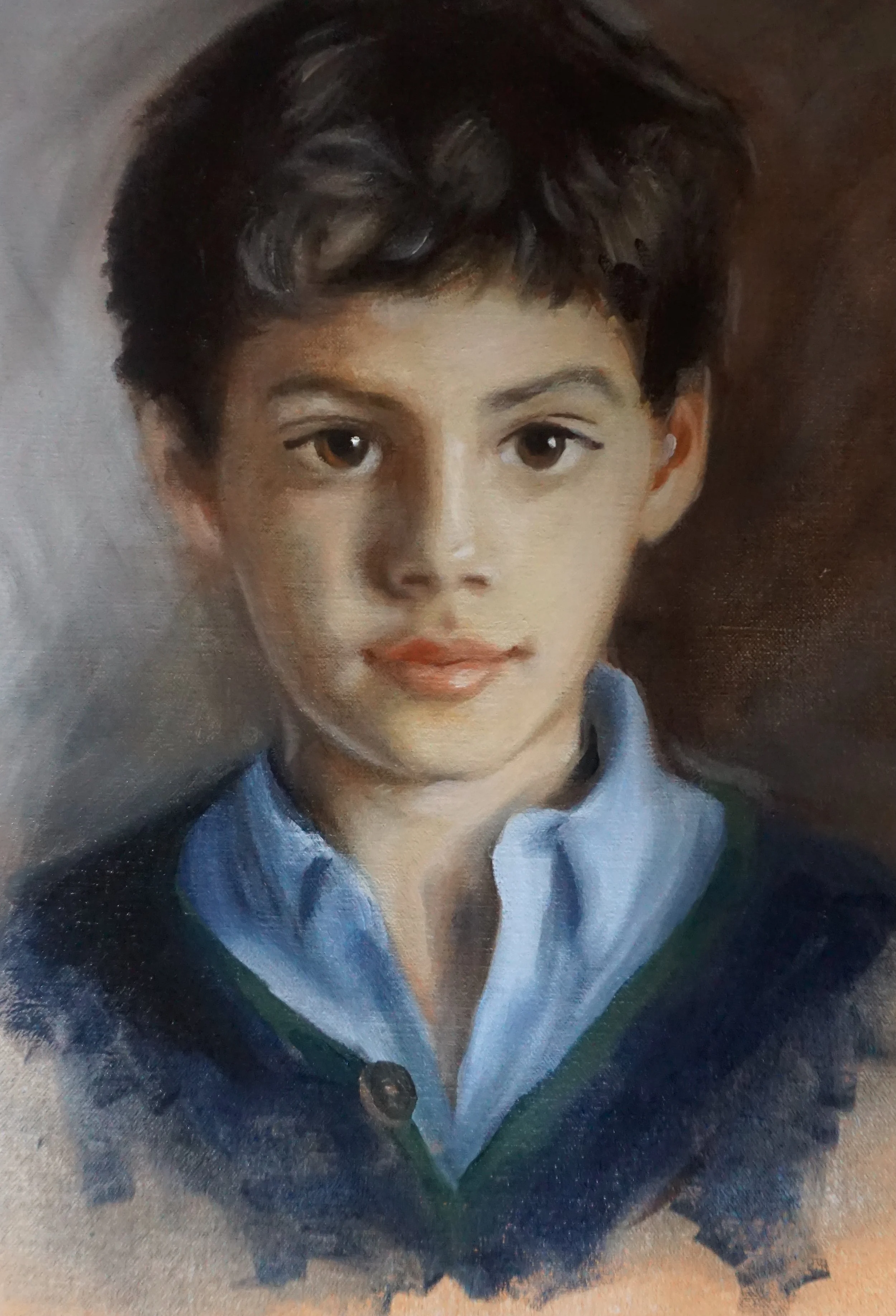 A realistic portrait of a young boy with short, dark curly hair, brown eyes, and a fair skin tone, wearing a blue blazer over a collared shirt.