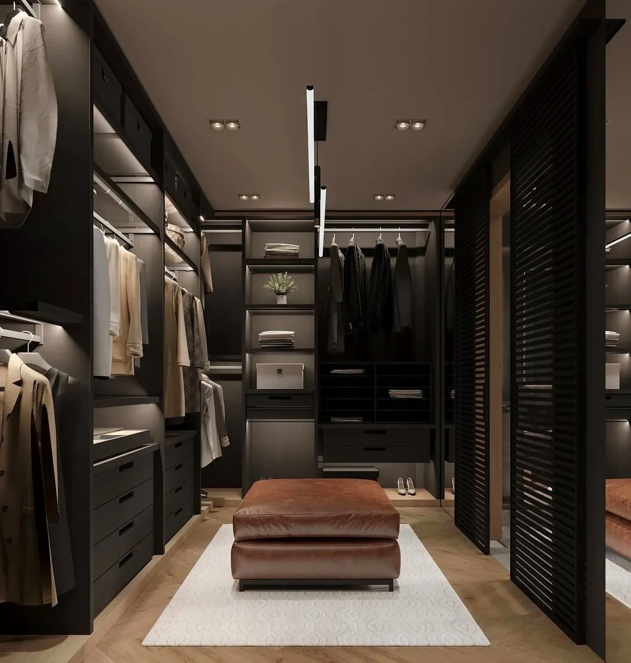 A walk-in closet with black shelving and hanging space for clothes, a brown leather ottoman, and a white rug on wooden flooring, illuminated by modern ceiling lighting.