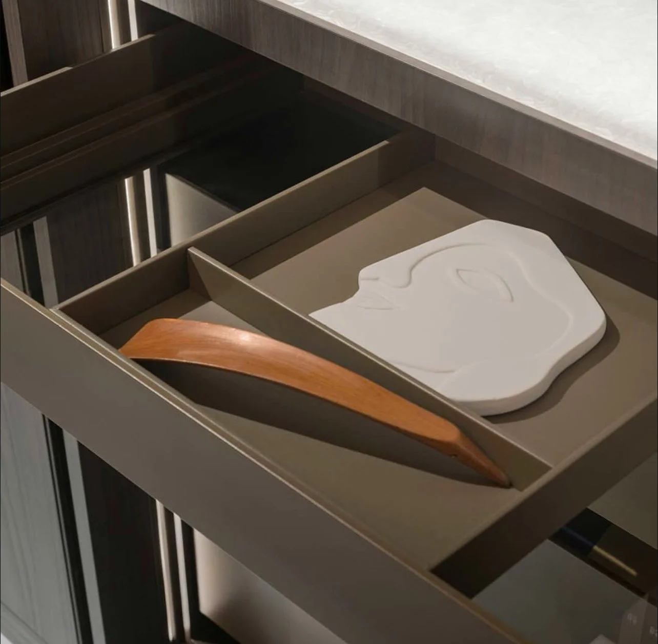 Open drawer with a carved white soap and a wooden soap dish inside.