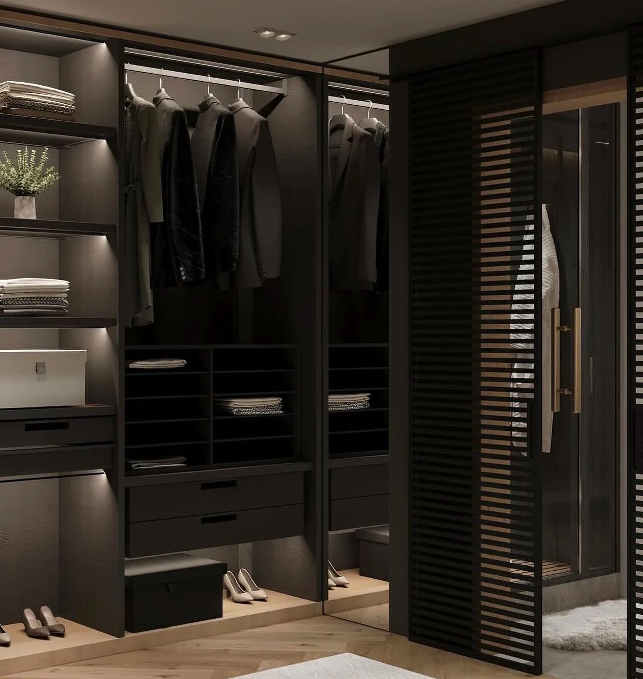 A walk-in closet with dark wood shelves and hanging clothes, including suits and jackets, and shelves with folded clothes and shoes, illuminated by built-in lighting.