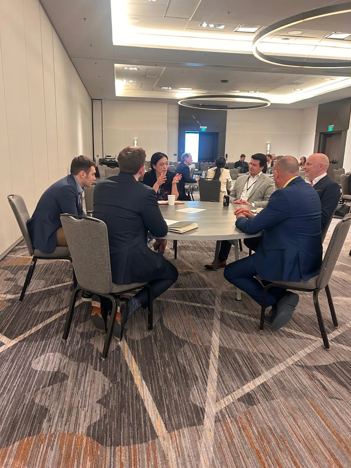 Five people sitting around a round table having a discussion at a conference room.  Advanced Wound Care Summit AWCS