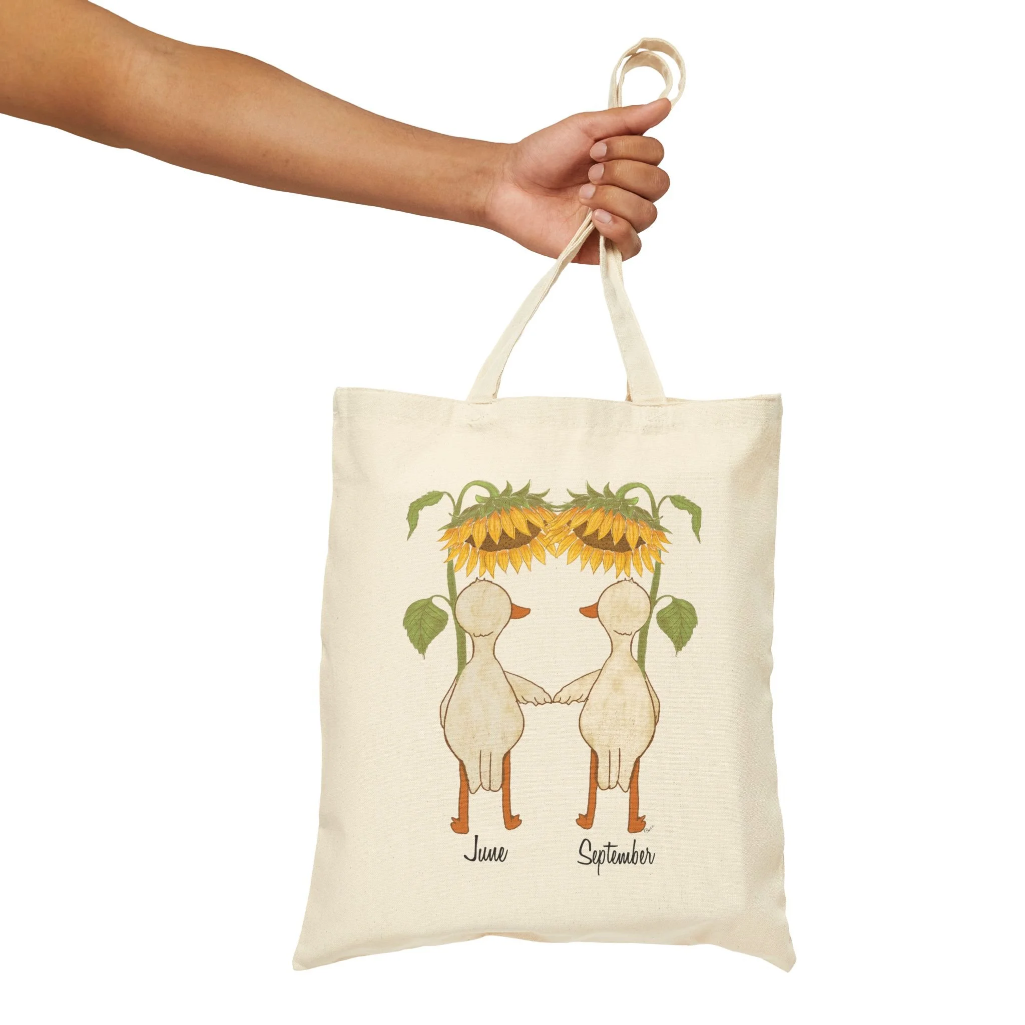 Cotton Tote Bag in hand featuring hand illustrated ducks or geese with large sunflowers as umbrellas available for personalization