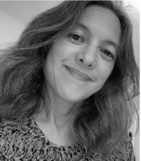 Black and white portrait of a woman with wavy hair smiling at the camera.