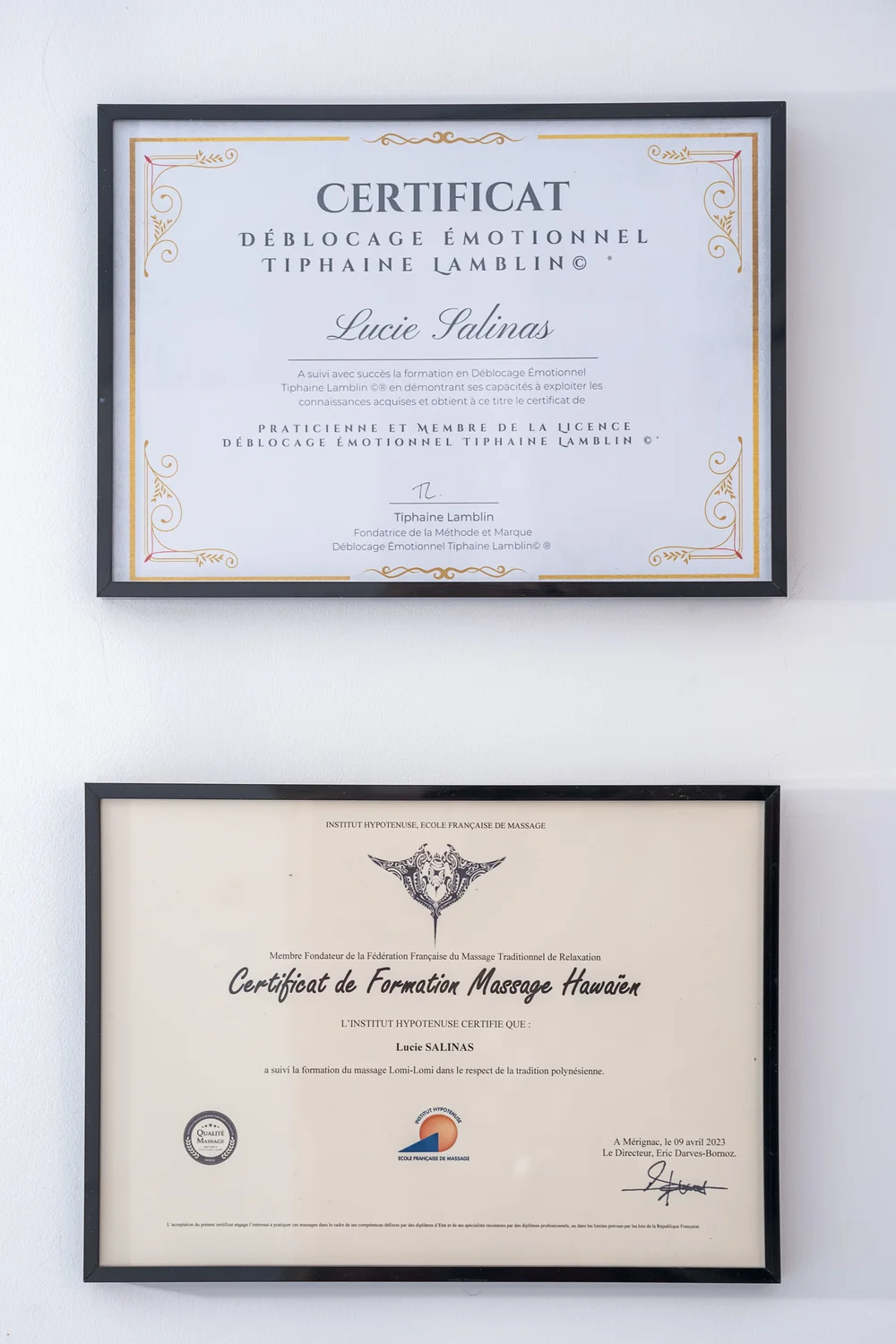 Diplômes et certificats de formation encadrés au mur du cabinet