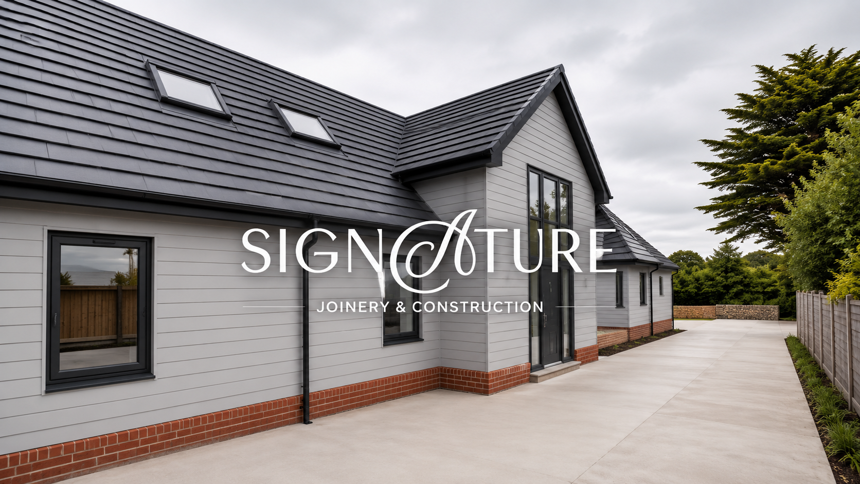 image of a new build project with grey cladding and stone wold roof tiles with a small red brick feature