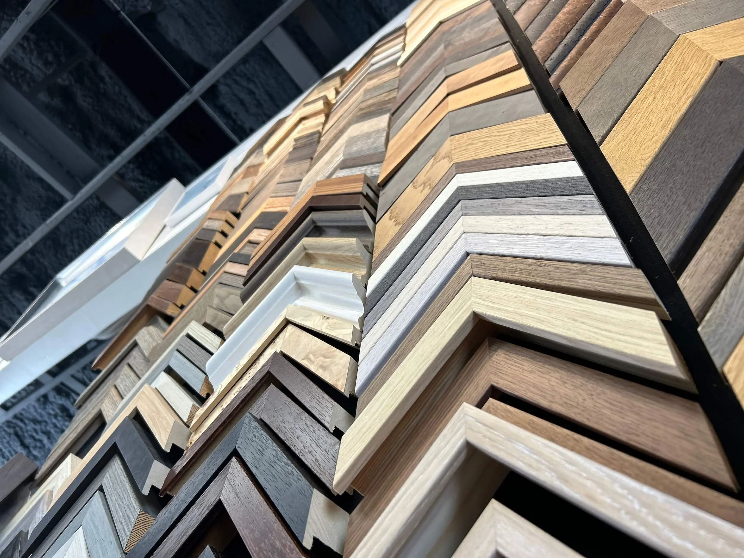 A display of various wood frame samples arranged in rows, showcasing different colors, textures, and finishes.