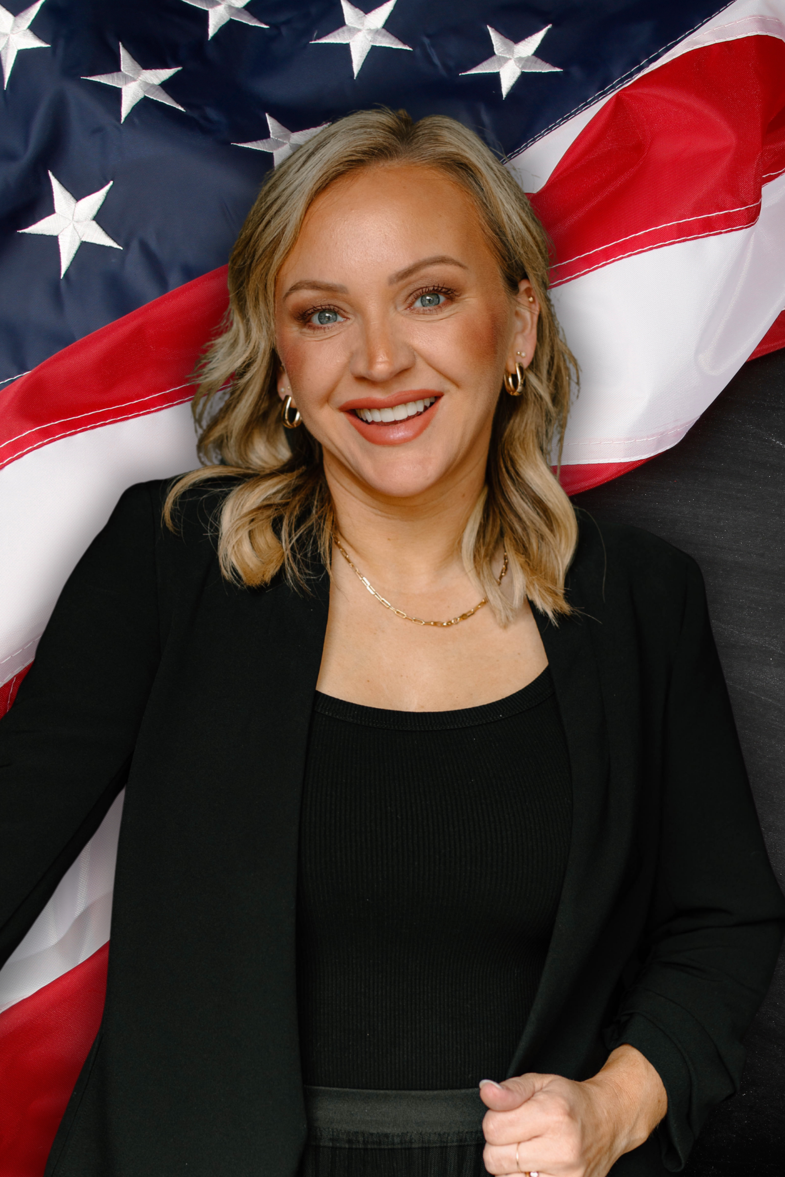 Molly Radakrishnana Headshot 2026 in front of an American flag.