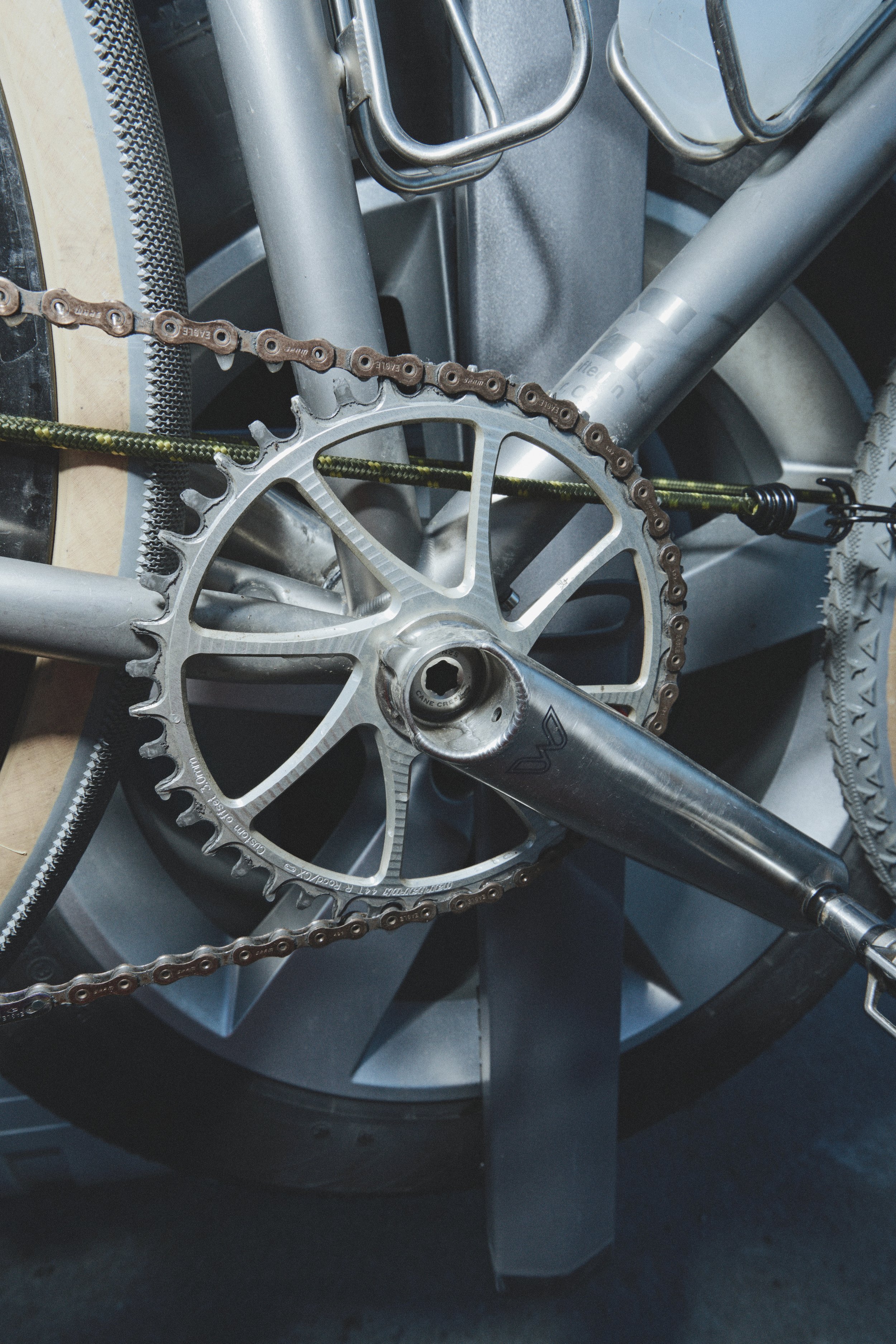 Close-up of a bicycle's chainring, crank arm, and chain, part of the bike's drivetrain system.