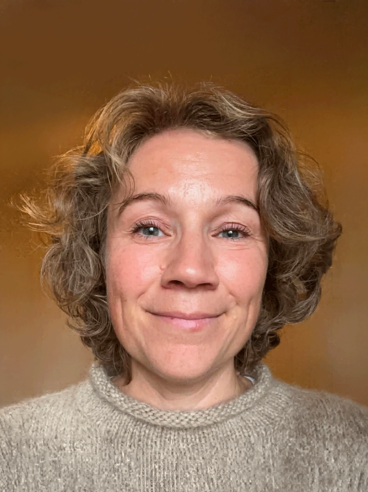 Headshot of smiling female tutor with short blonde hair wearing a lanyard.