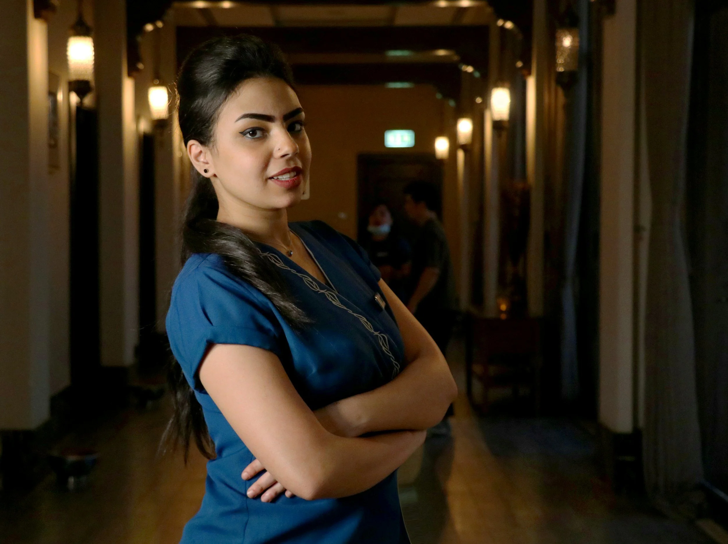 Healthcare professional in scrubs standing in a clinic hallway