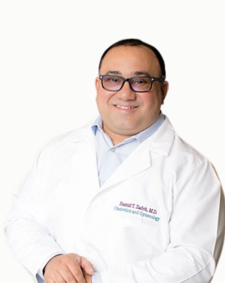 Portrait of a male doctor wearing glasses and a white coat, smiling.