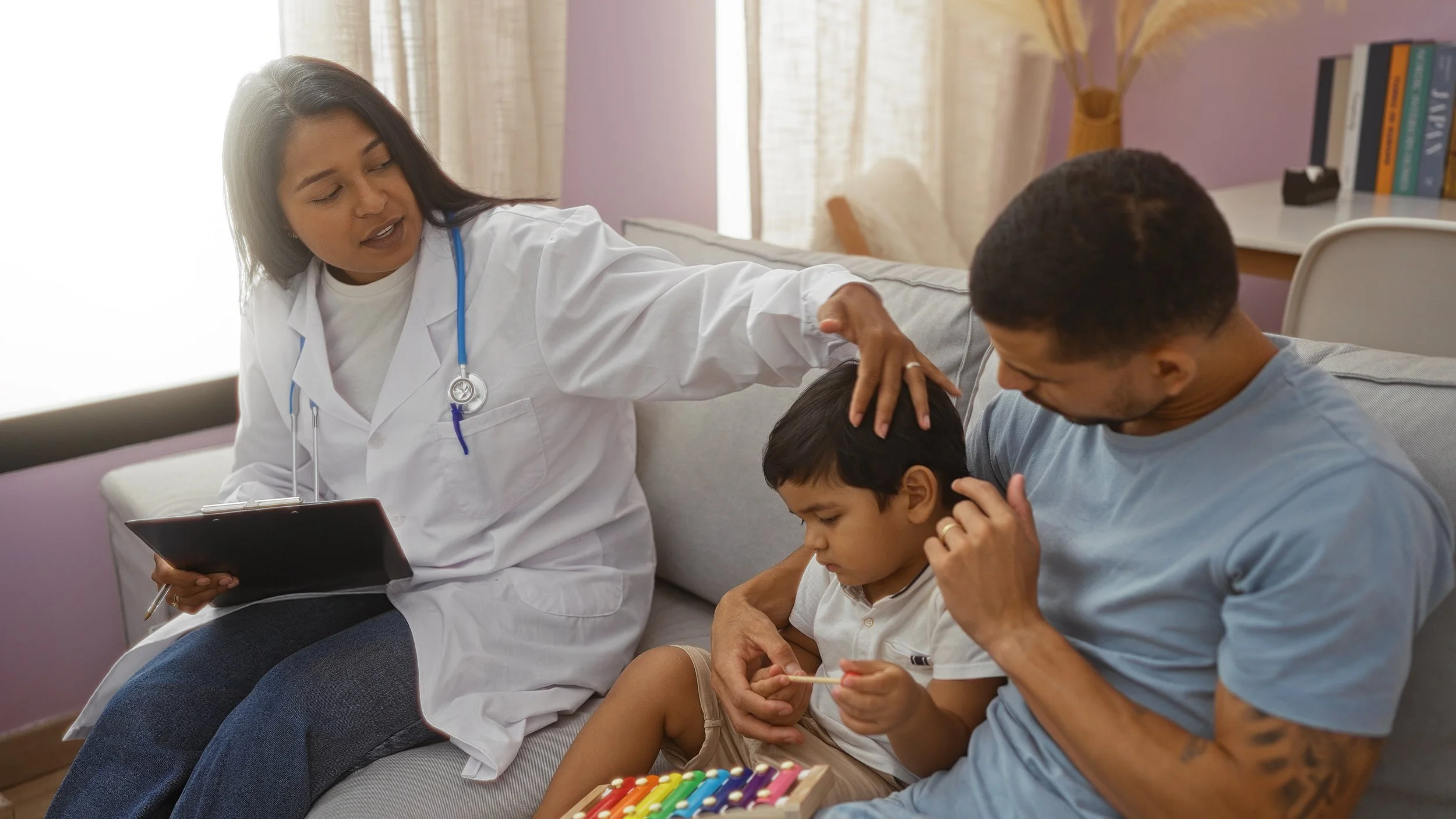 A female healthcare professional, wearing a white coat and stethoscope, examining two young boys with a sympathetic expression in a cozy, well-lit Imperial California clinical trials room