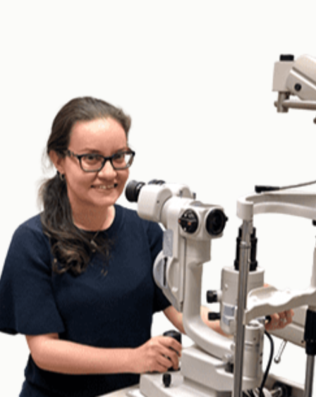 A woman using a slit lamp microscope for eye examination.