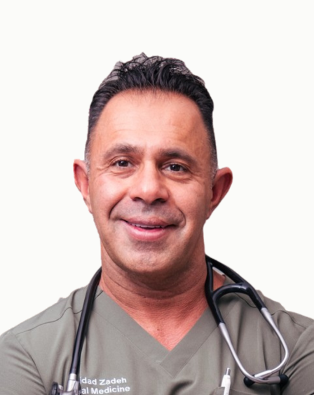 A male healthcare professional wearing a gray medical uniform and a stethoscope around his neck, smiling at the camera.