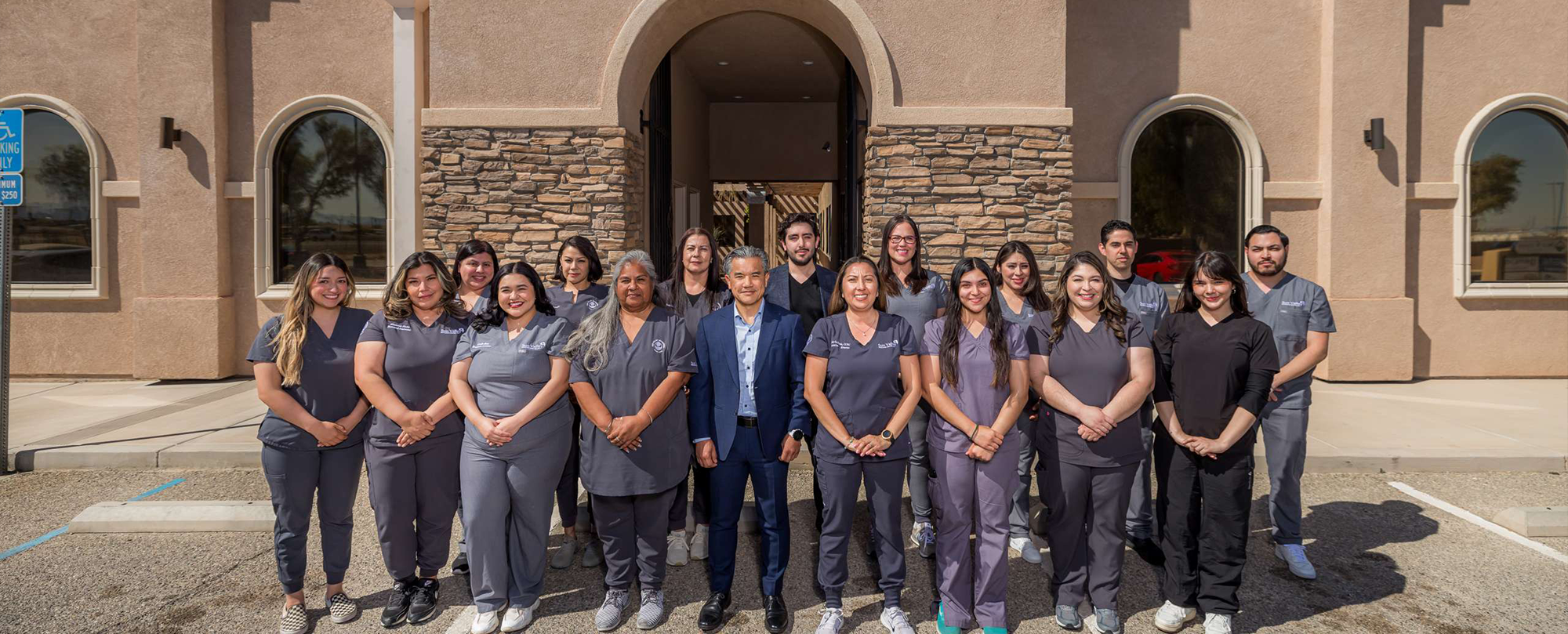 Group of healthcare professionals in Imperial, California and staff standing outside of a building, smiling for a team photo.