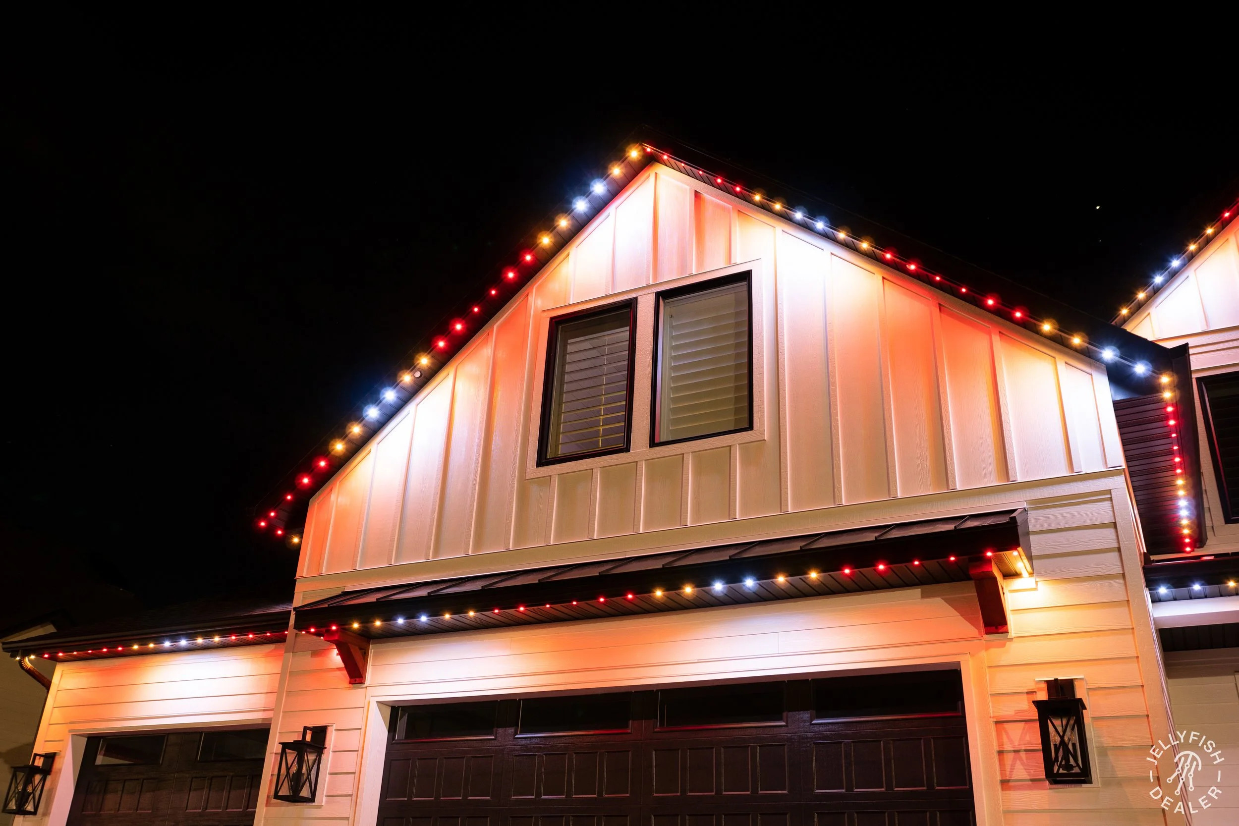 A house decorated with multicolored Christmas lights at night.