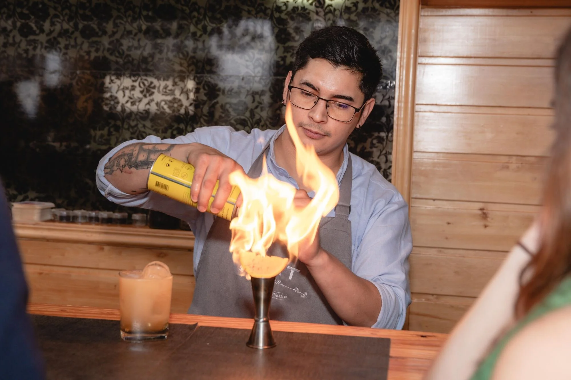Bartender preparando un cóctel flameado durante la celebración en Castro, Chiloé	