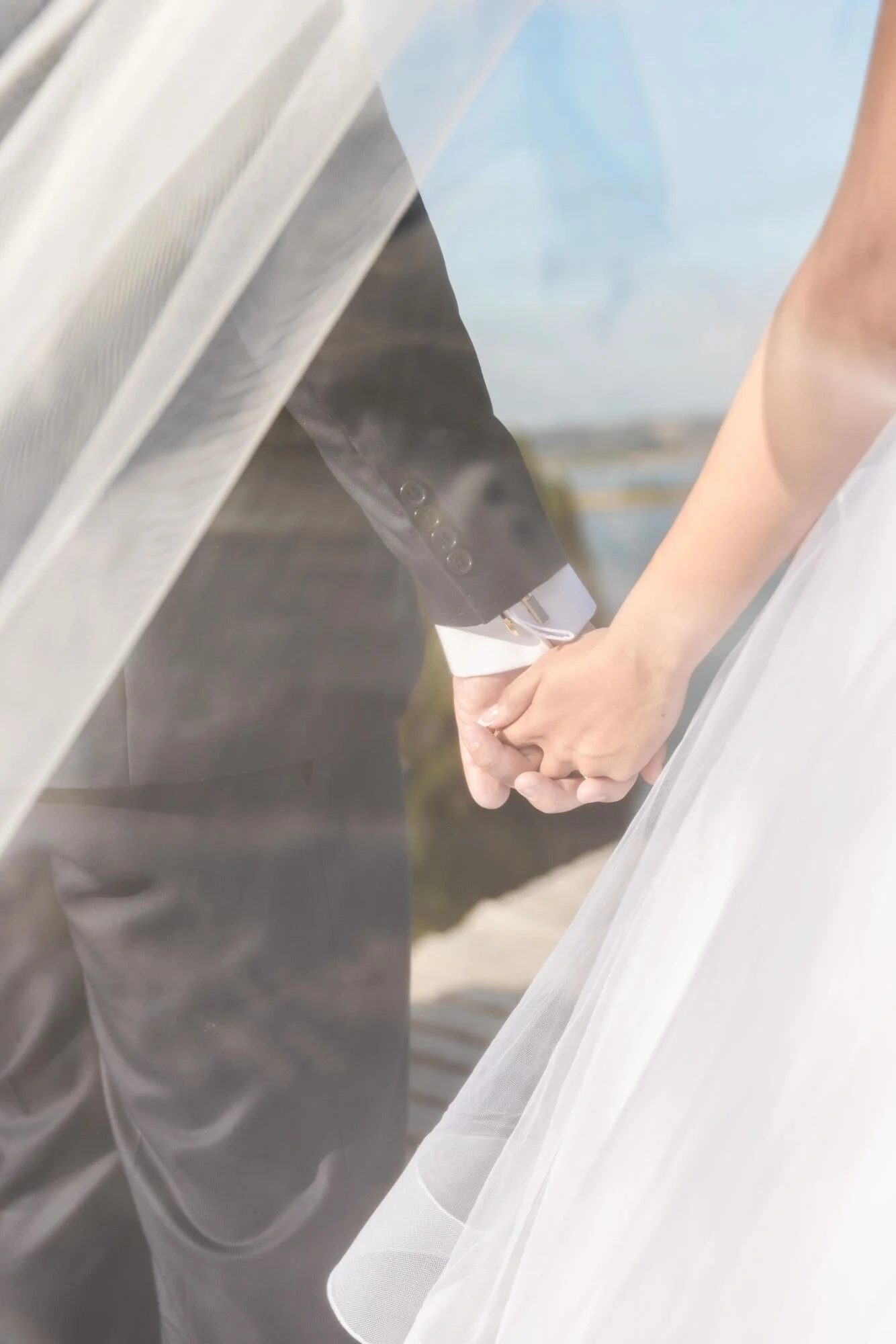 Detalle de las manos de los novios entre el velo, boda en Castro, Chiloé