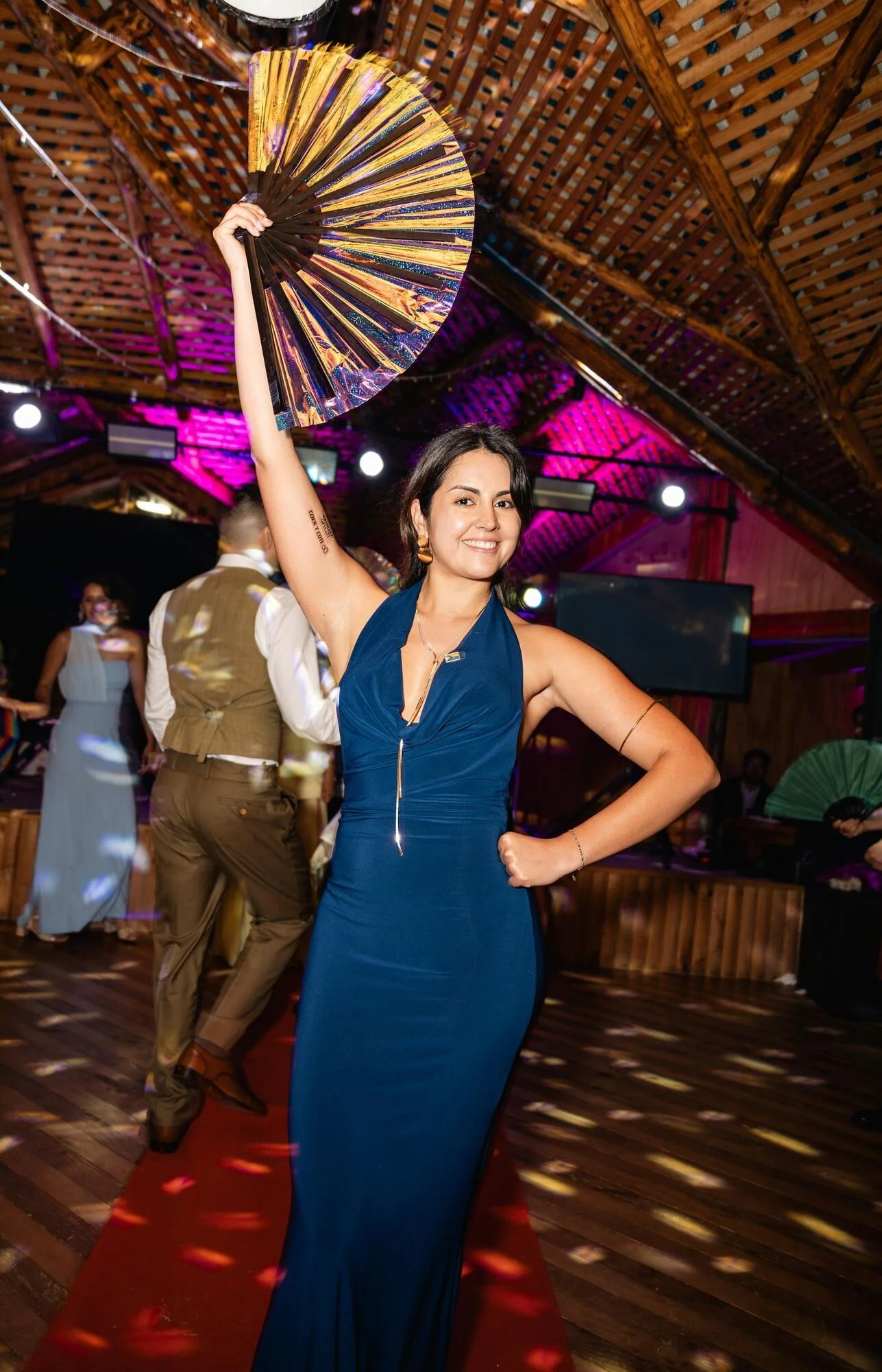 Invitada con vestido azul bailando con abanico en la fiesta de matrimonio en Chiloé