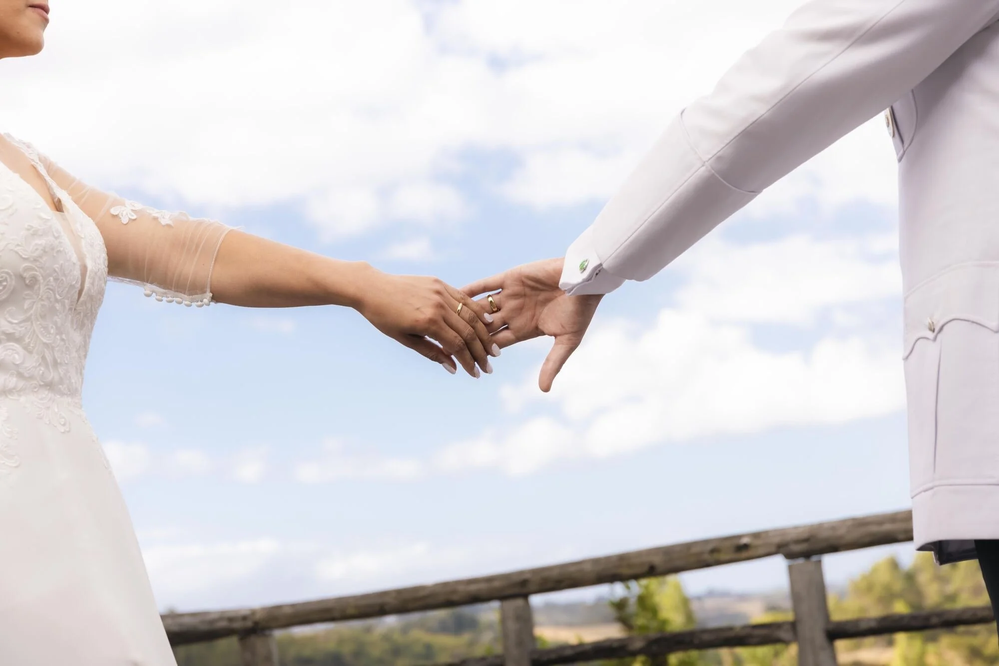 Detalle de las manos de los novios unidas contra el cielo en Quilquico, Chiloé