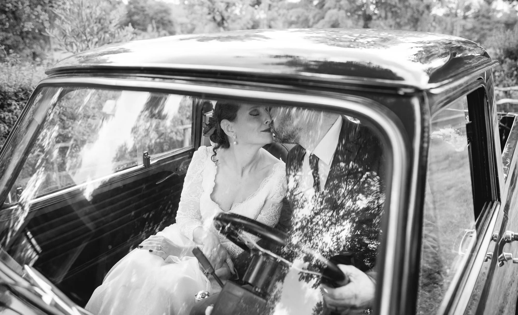 La novia al volante del auto clásico, fotografía en blanco y negro, boda en Chiloé	