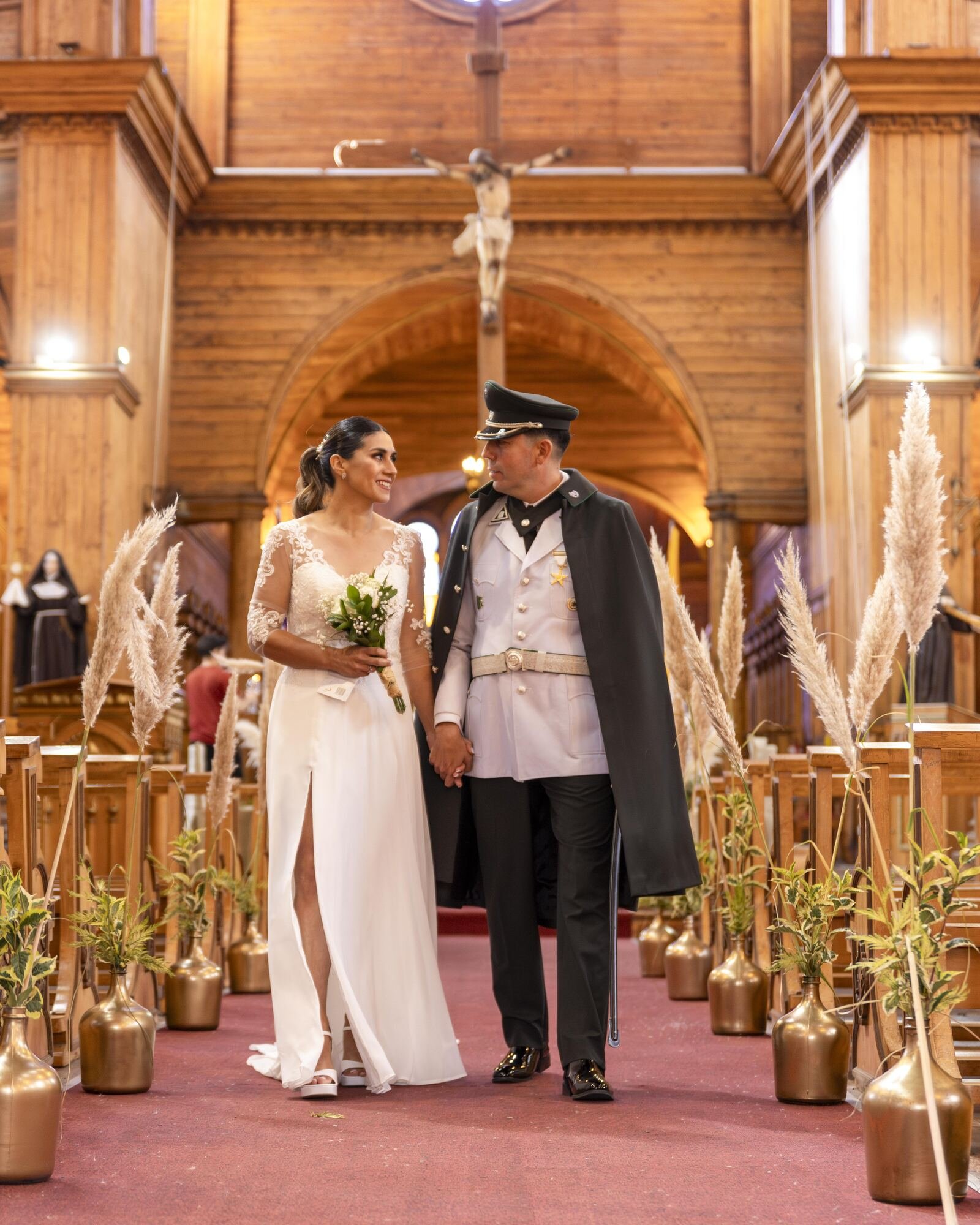 Los novios en el altar de la iglesia de madera durante su boda militar en Castro, Chiloé. 
