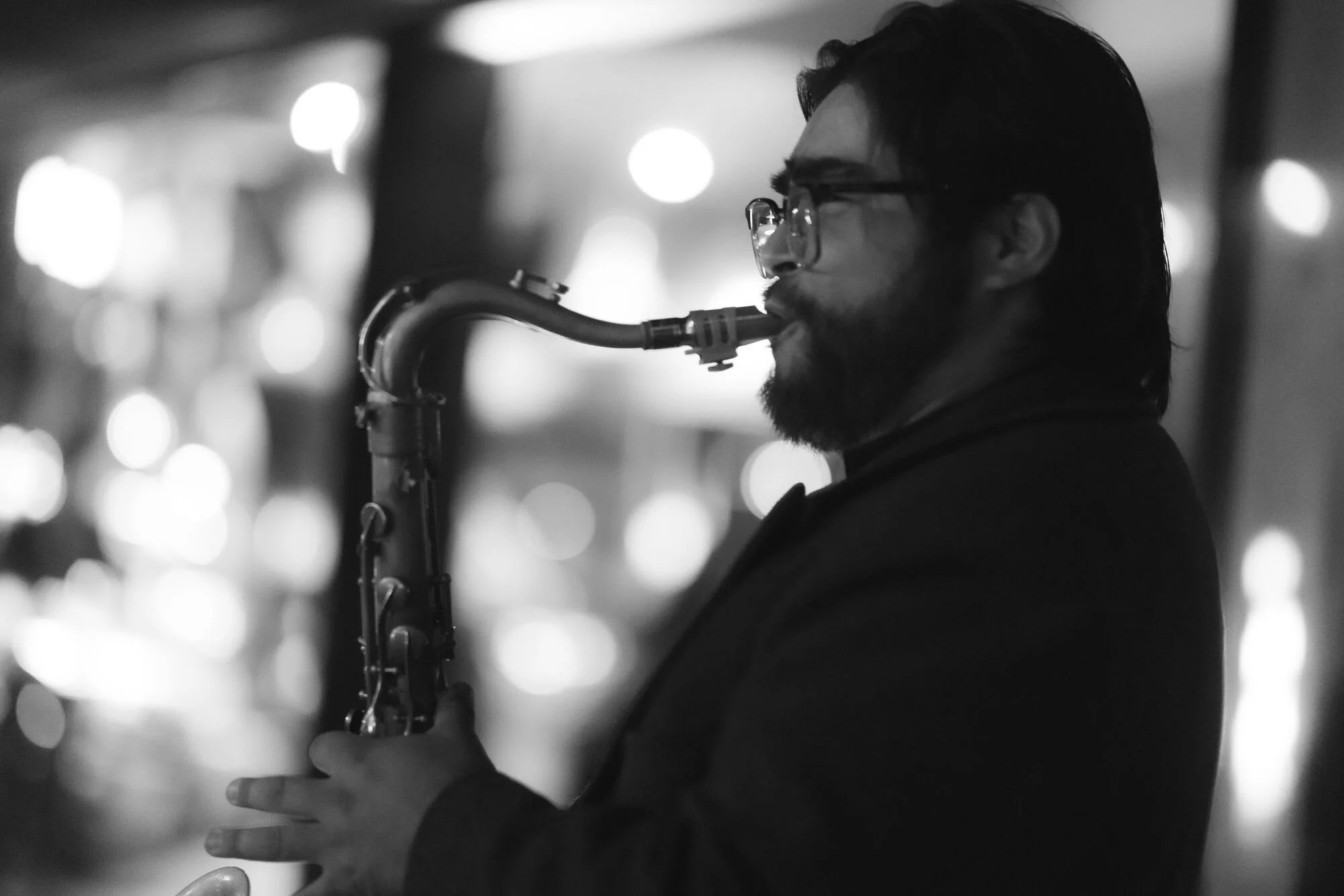 Saxofonista tocando en vivo durante la fiesta, en blanco y negro, Refugia, Castro