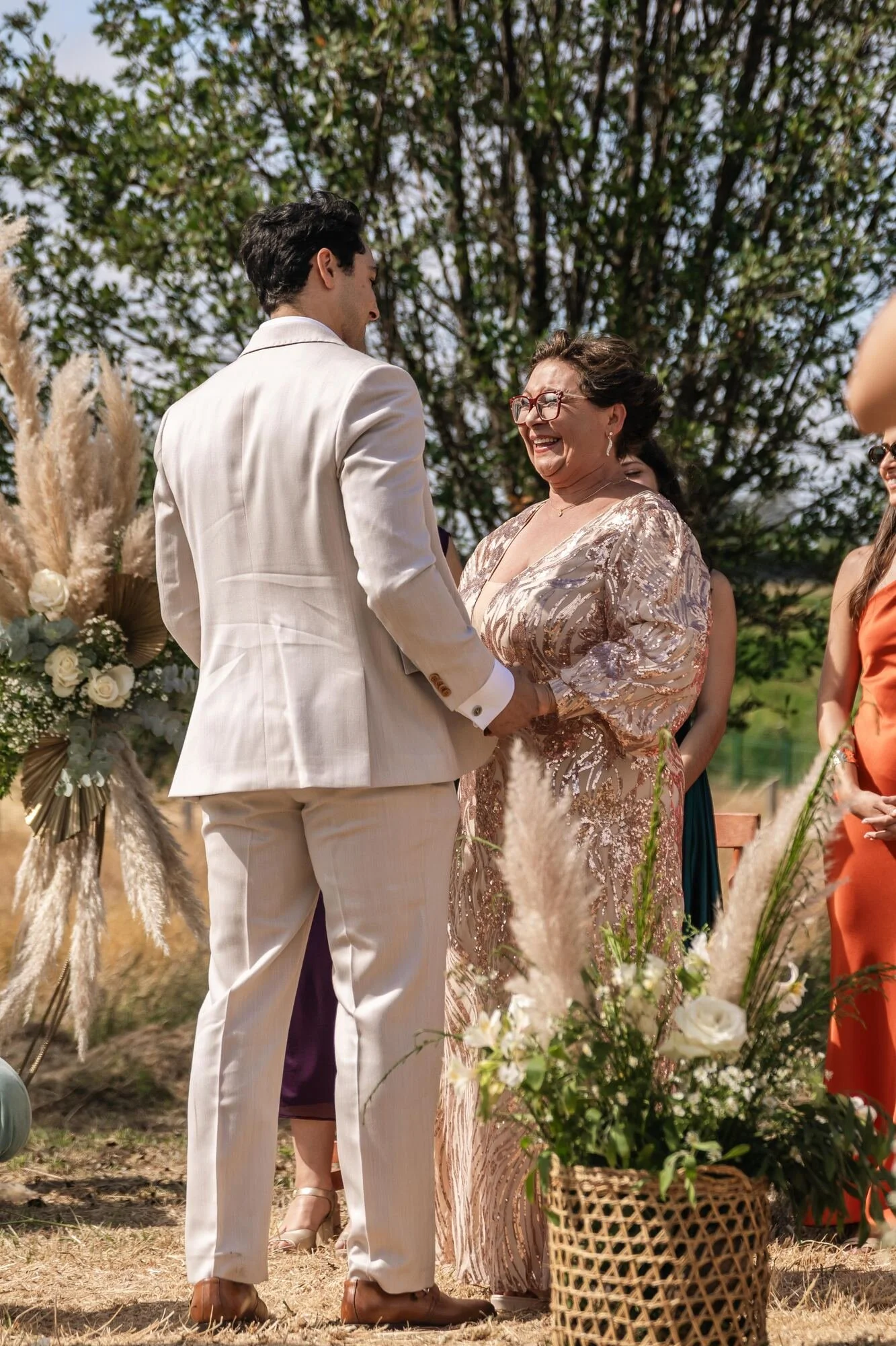 La madre acompaña al novio hasta el altar decorado con pampas en la ceremonia en Ancud