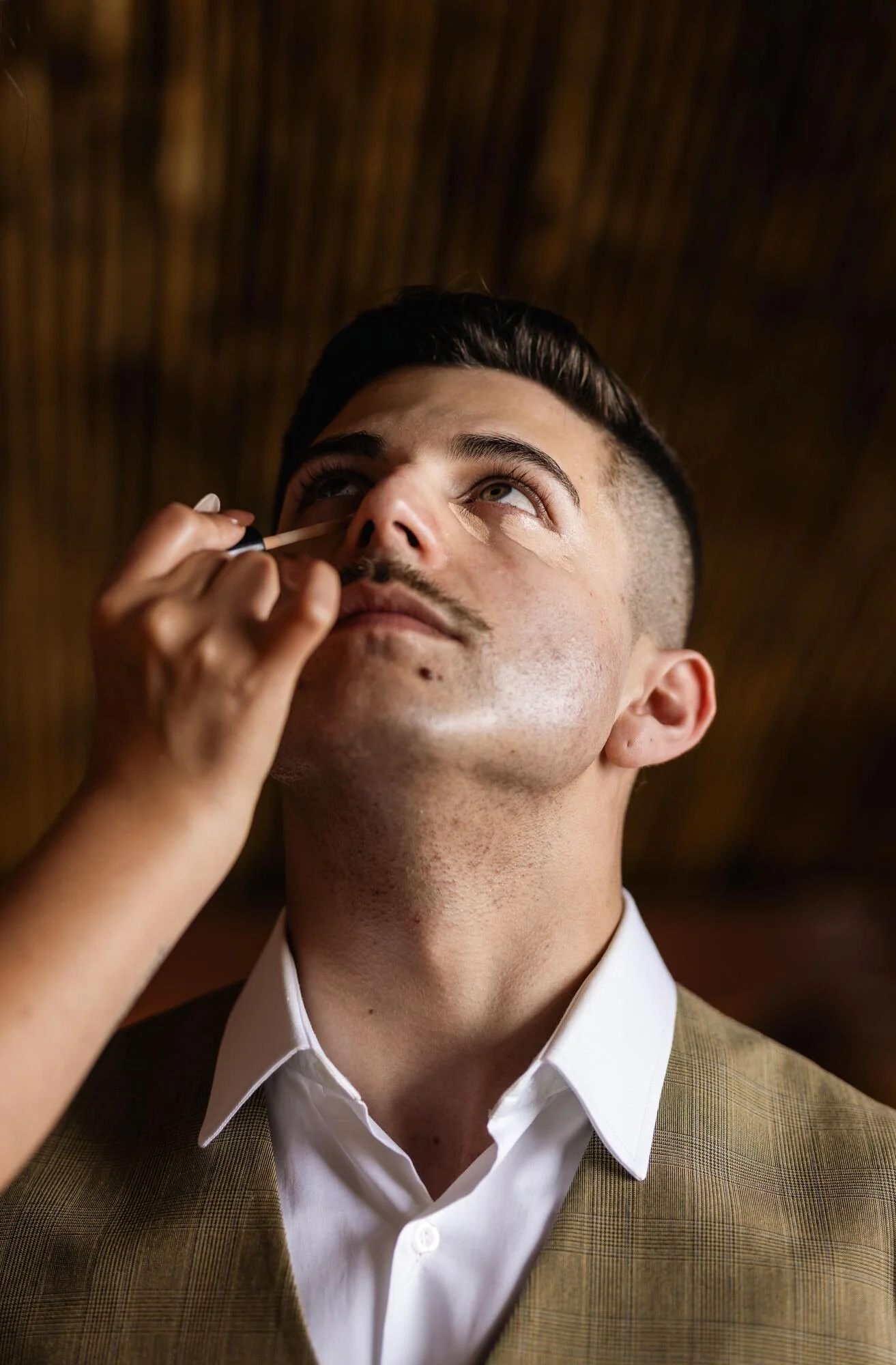 Maquillaje del novio durante los preparativos previos a la boda en Ancud, Chiloé