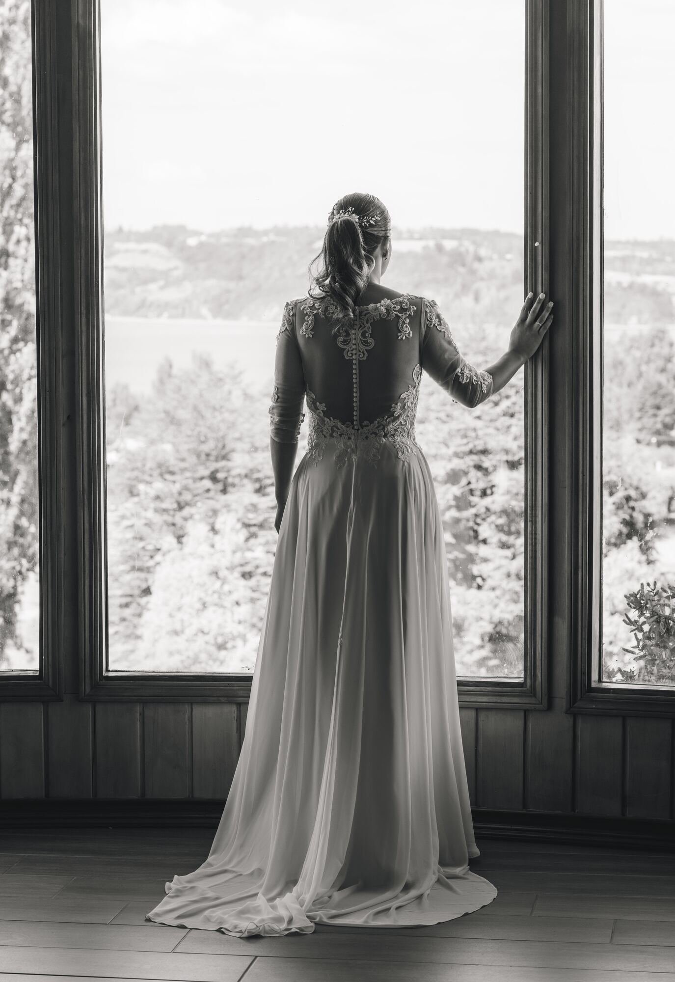 La novia de espaldas junto a la ventana, fotografía en blanco y negro, boda en Chiloé