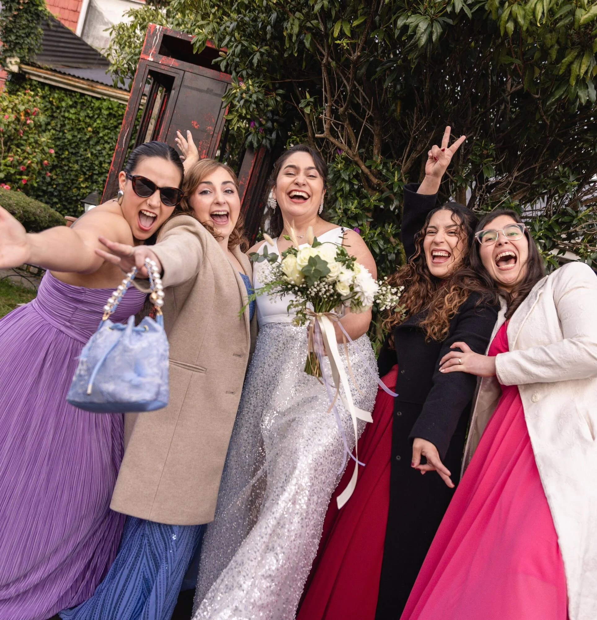 La novia celebrando con sus amigas en el jardín durante la boda en Castro, Chiloé	