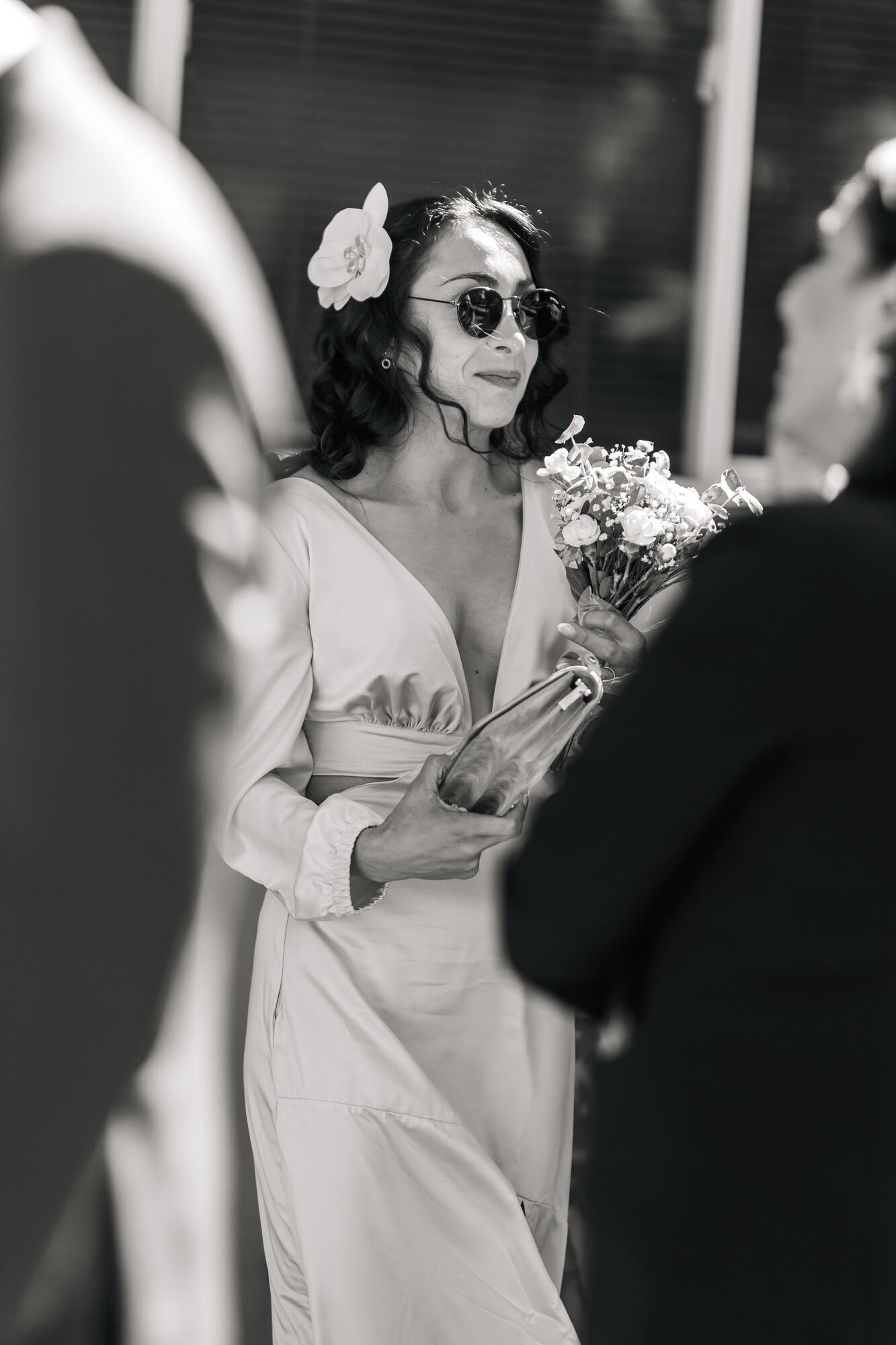 La novia con su ramo y lentes de sol, en blanco y negro, boda en Dalcahue, Chiloé	