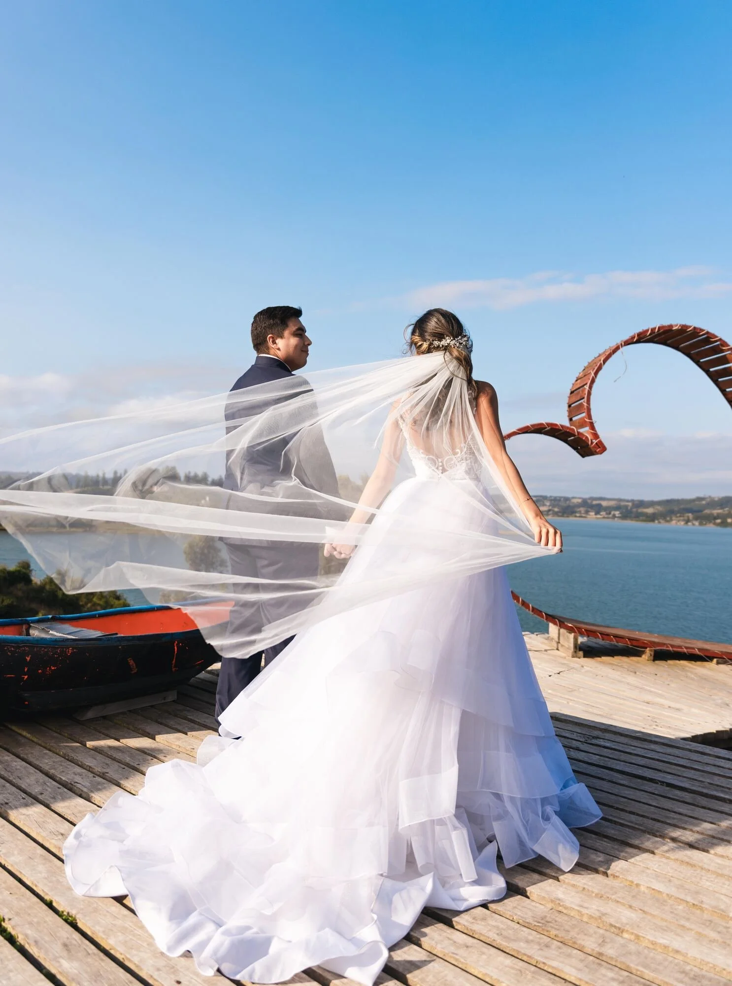 La cola del vestido de la novia extendida en el mirador con vista al mar, Castro, Chiloé	