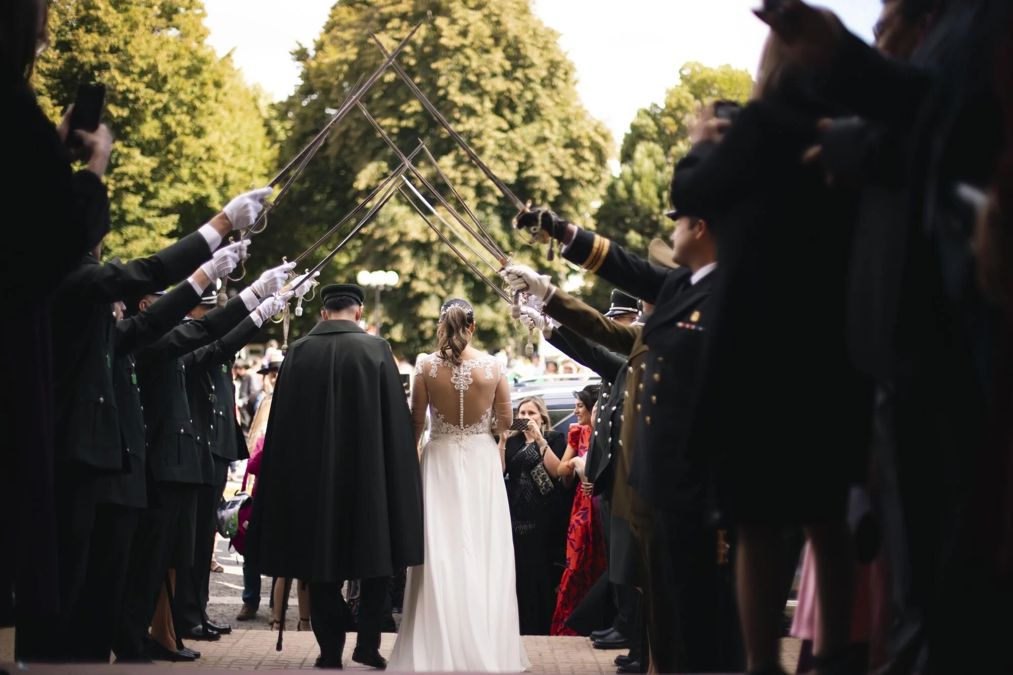 Los novios cruzan la calle de honor con sables entre confeti, boda militar en Castro, Chiloé