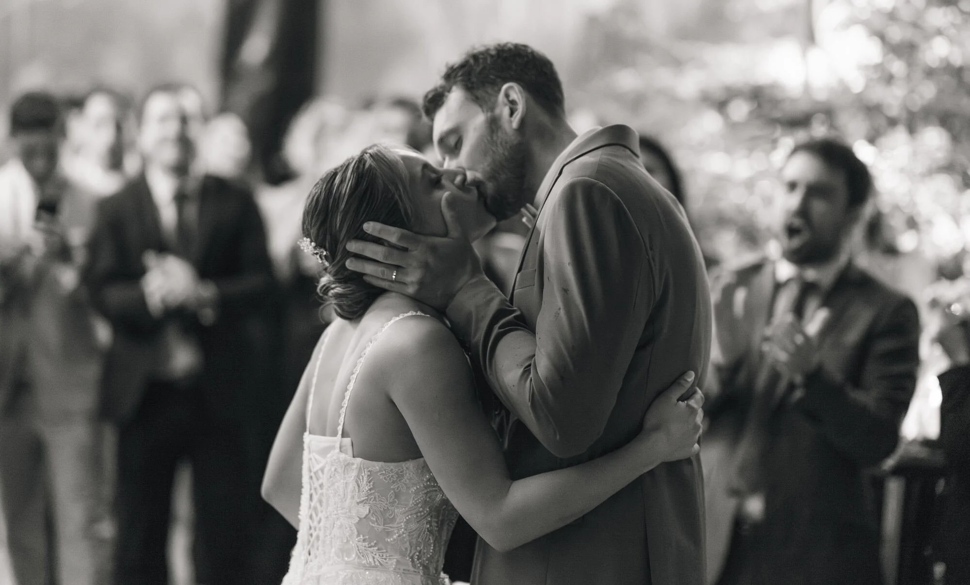 Beso de los novios visto entre los invitados, en blanco y negro, Refugia, Castro