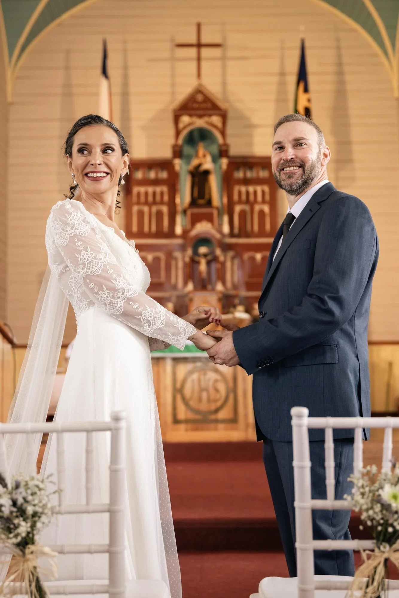 Los novios tomados de la mano en el altar de una iglesia patrimonial de Chiloé	