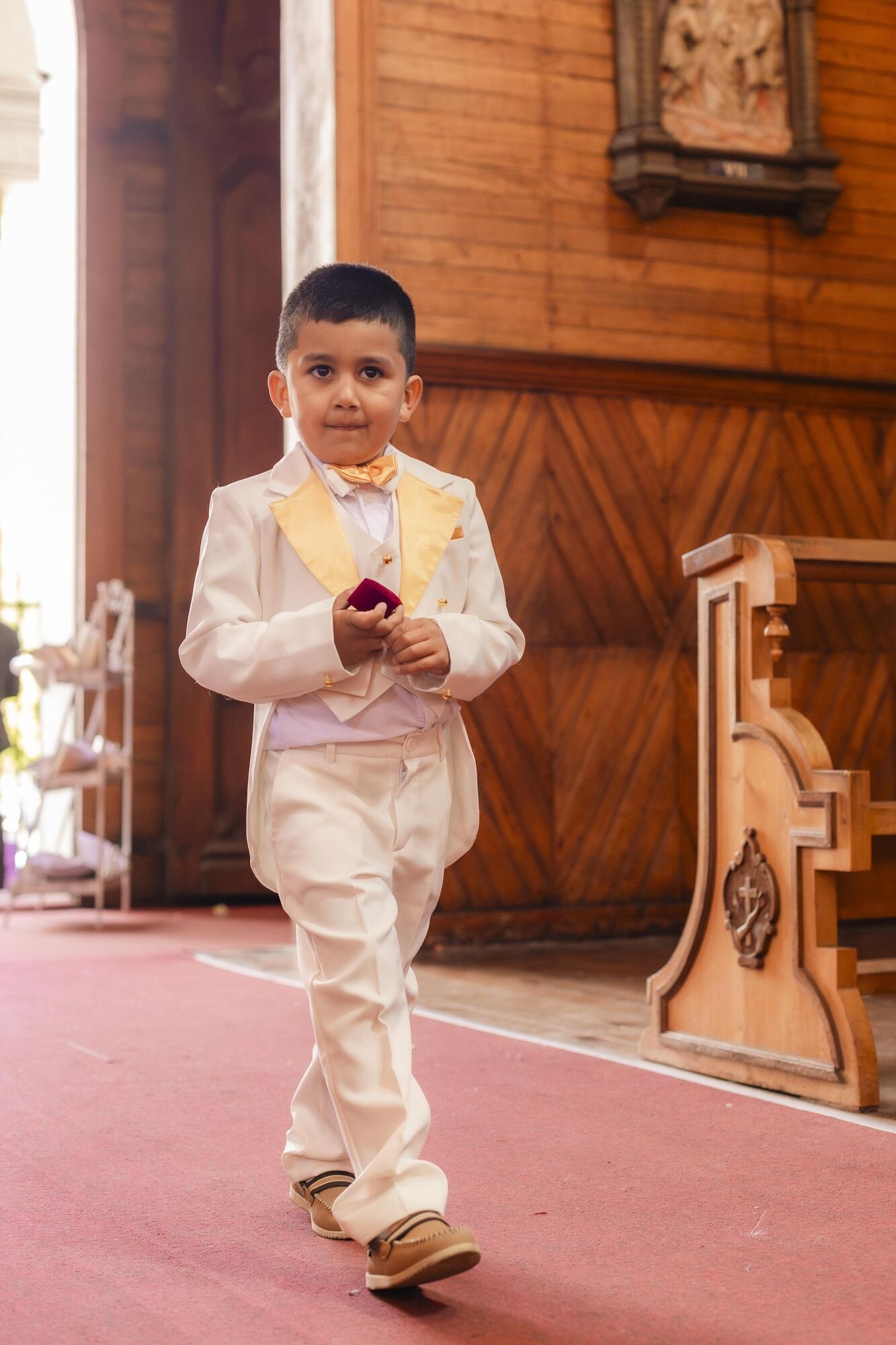 Niño de las arras caminando por el pasillo de la iglesia en Castro, Chiloé
