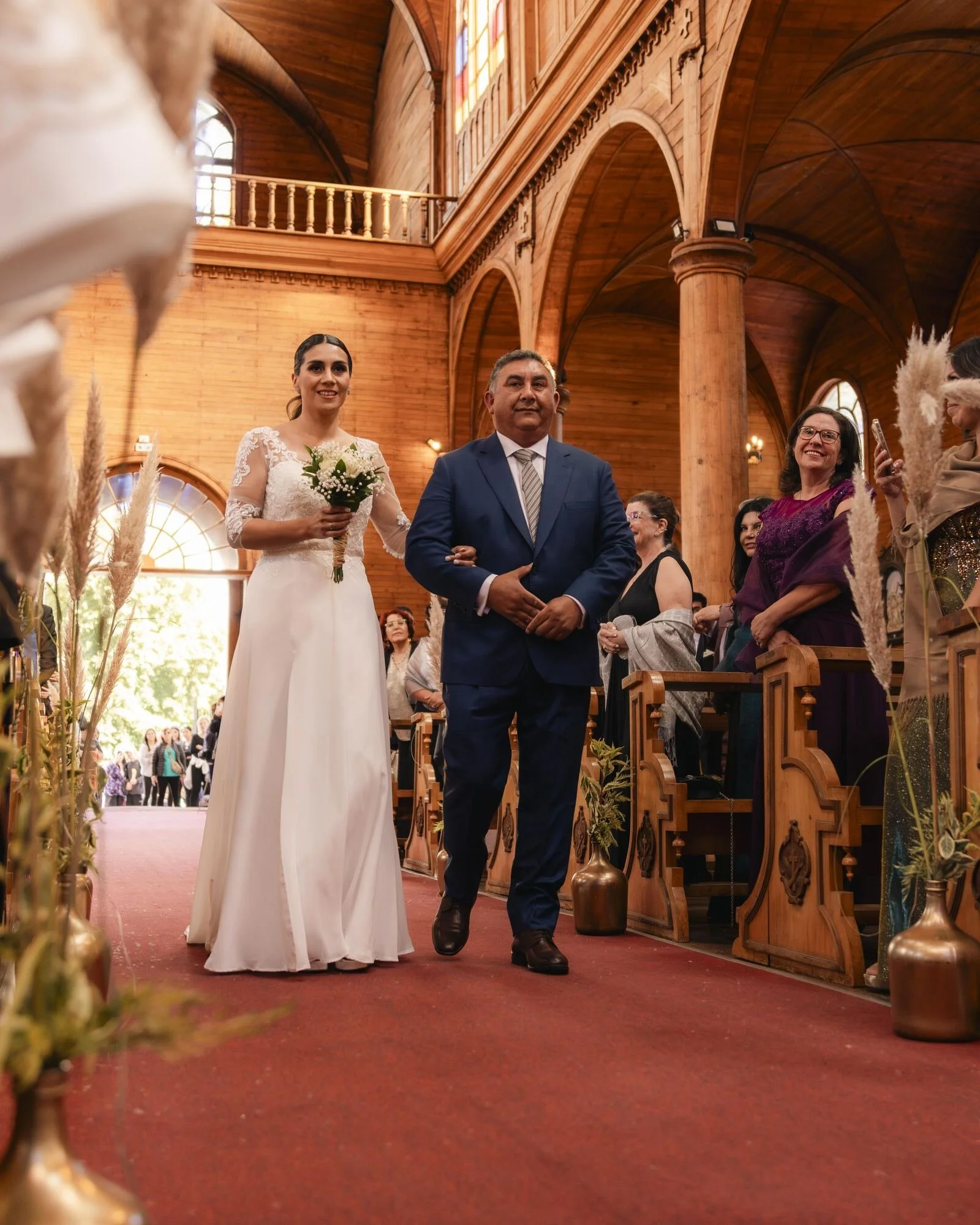 Entrada de la novia acompañada de su padre en una iglesia de madera de Chiloé