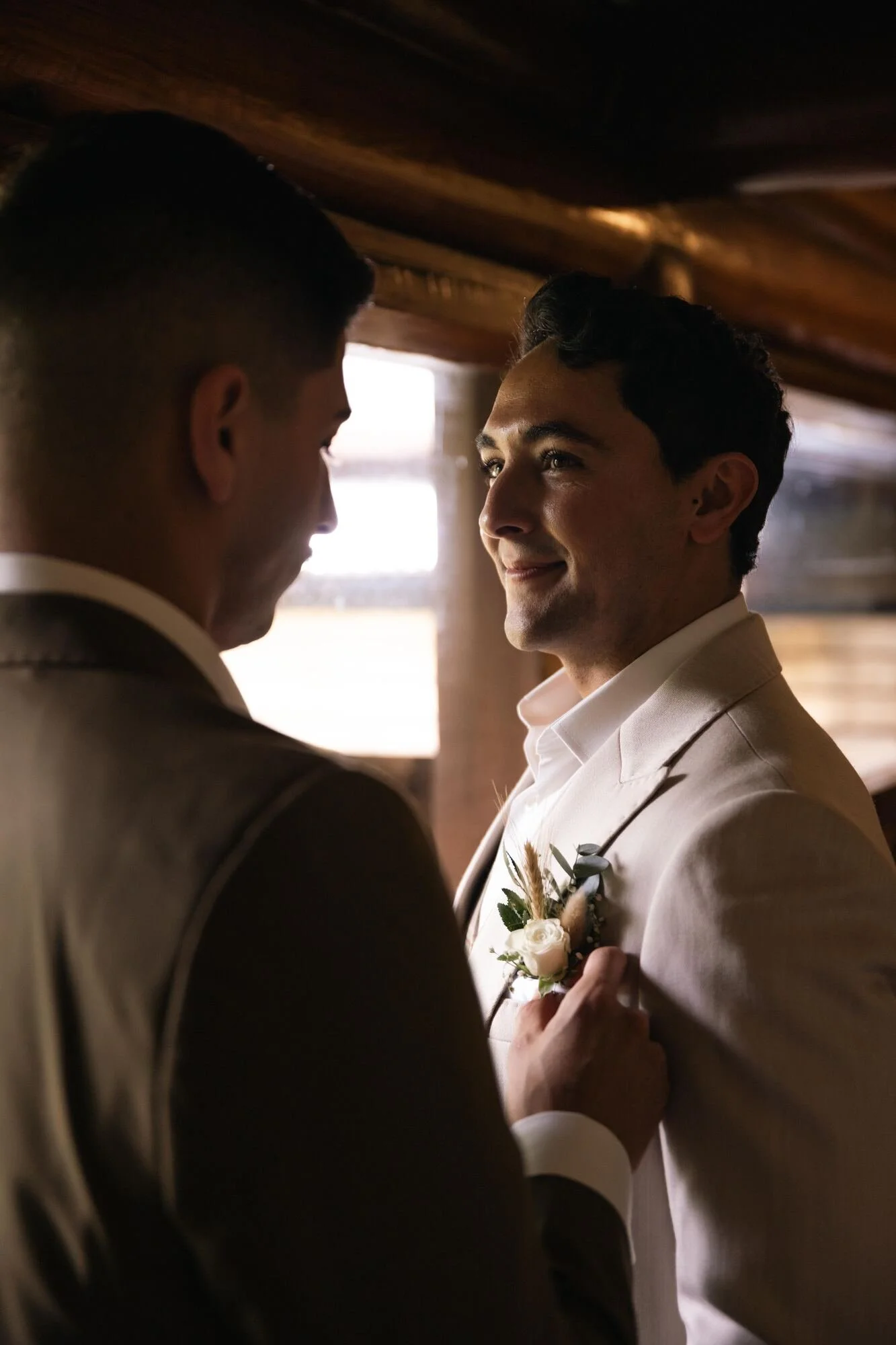 Los novios mirándose junto a la ventana antes de la ceremonia en Ancud, Chiloé