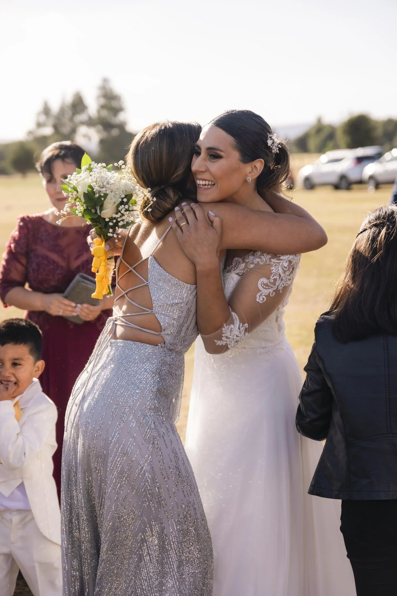 La novia abraza a una amiga durante la recepción campestre en Quilquico, Chiloé