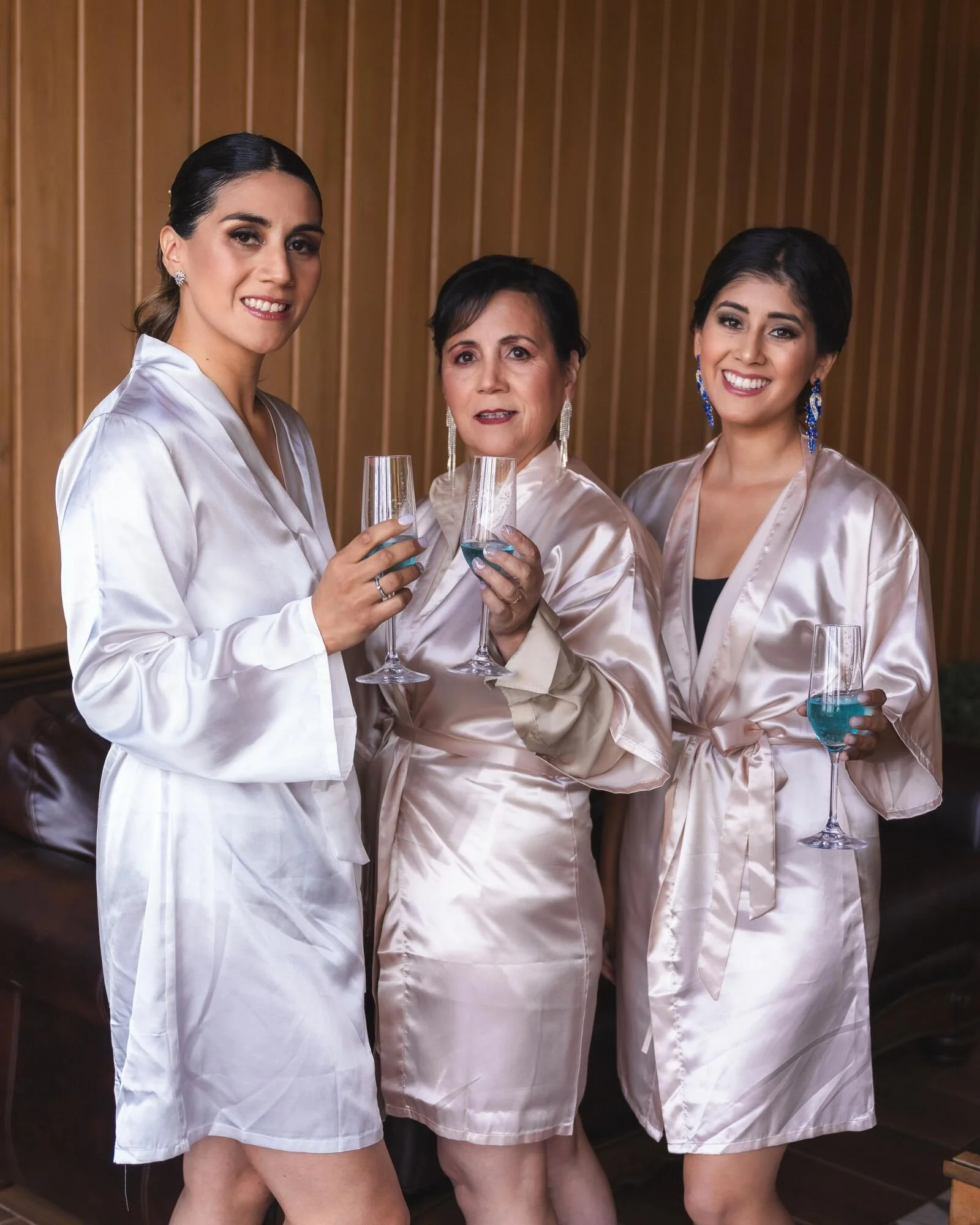 Damas de honor brindando en bata durante los preparativos de la boda en Chiloé
