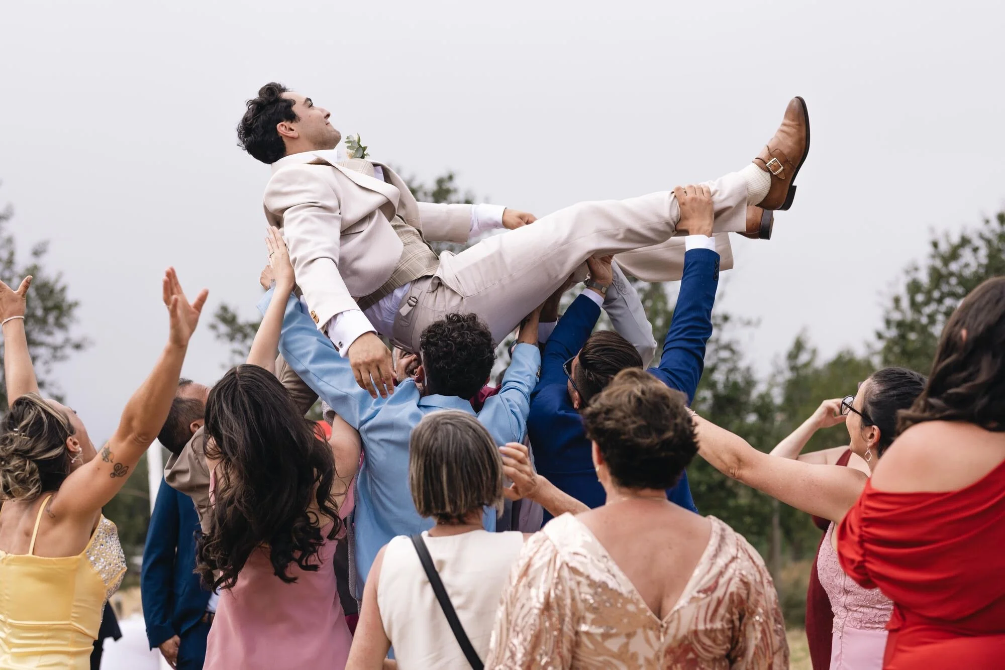 Los invitados levantan en andas al novio durante la celebración de la boda en Ancud