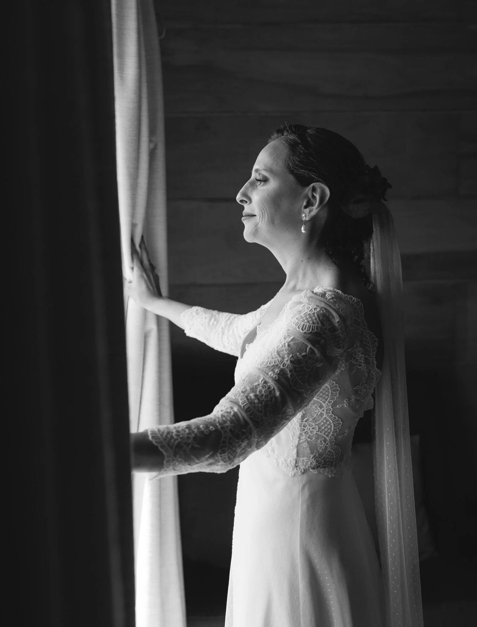 La novia junto a la ventana antes de la ceremonia, en blanco y negro, Quilquico, Chiloé	